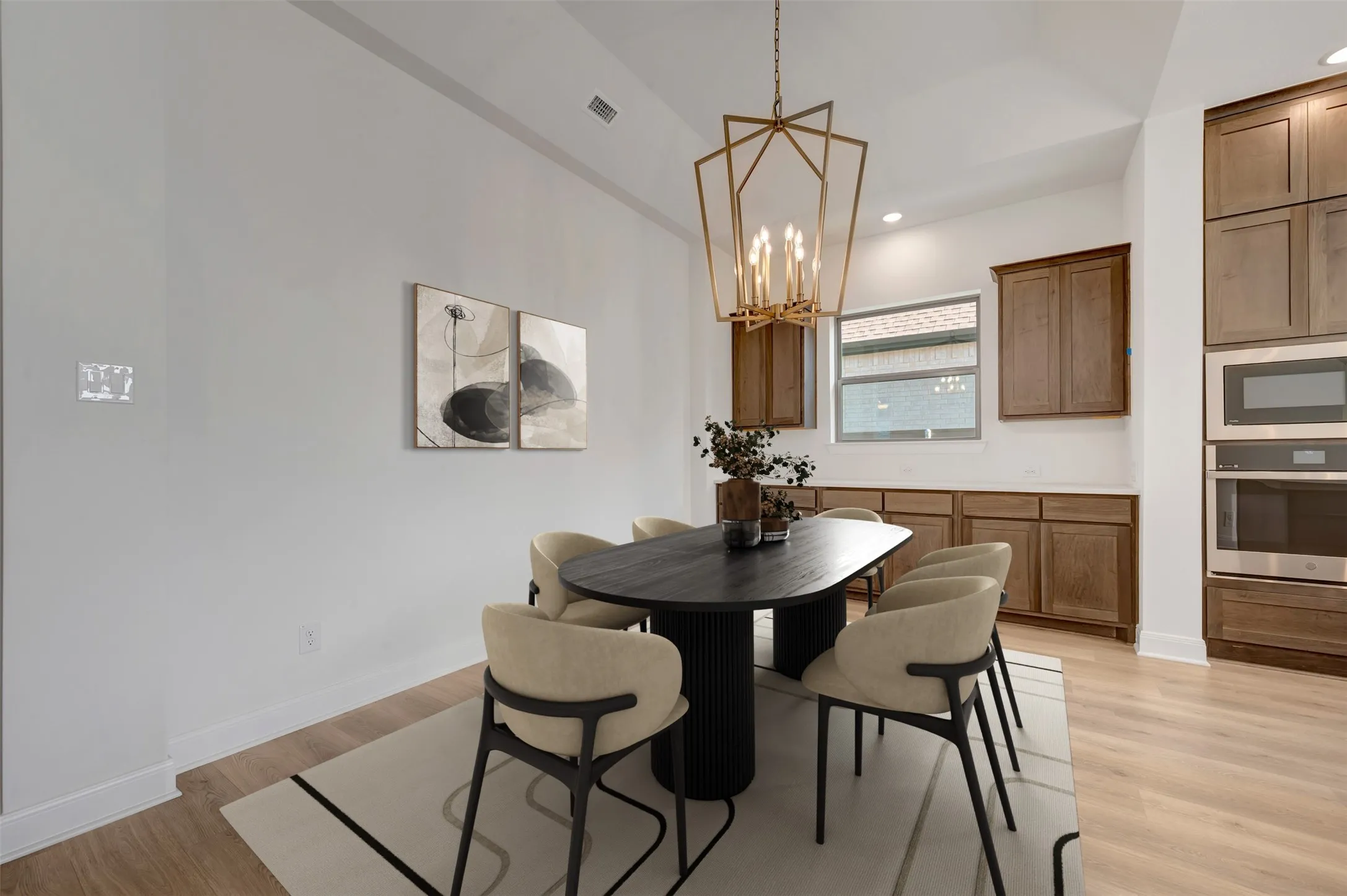 Open-concept dining area featuring a geometric chandelier and light wood-finish flooring