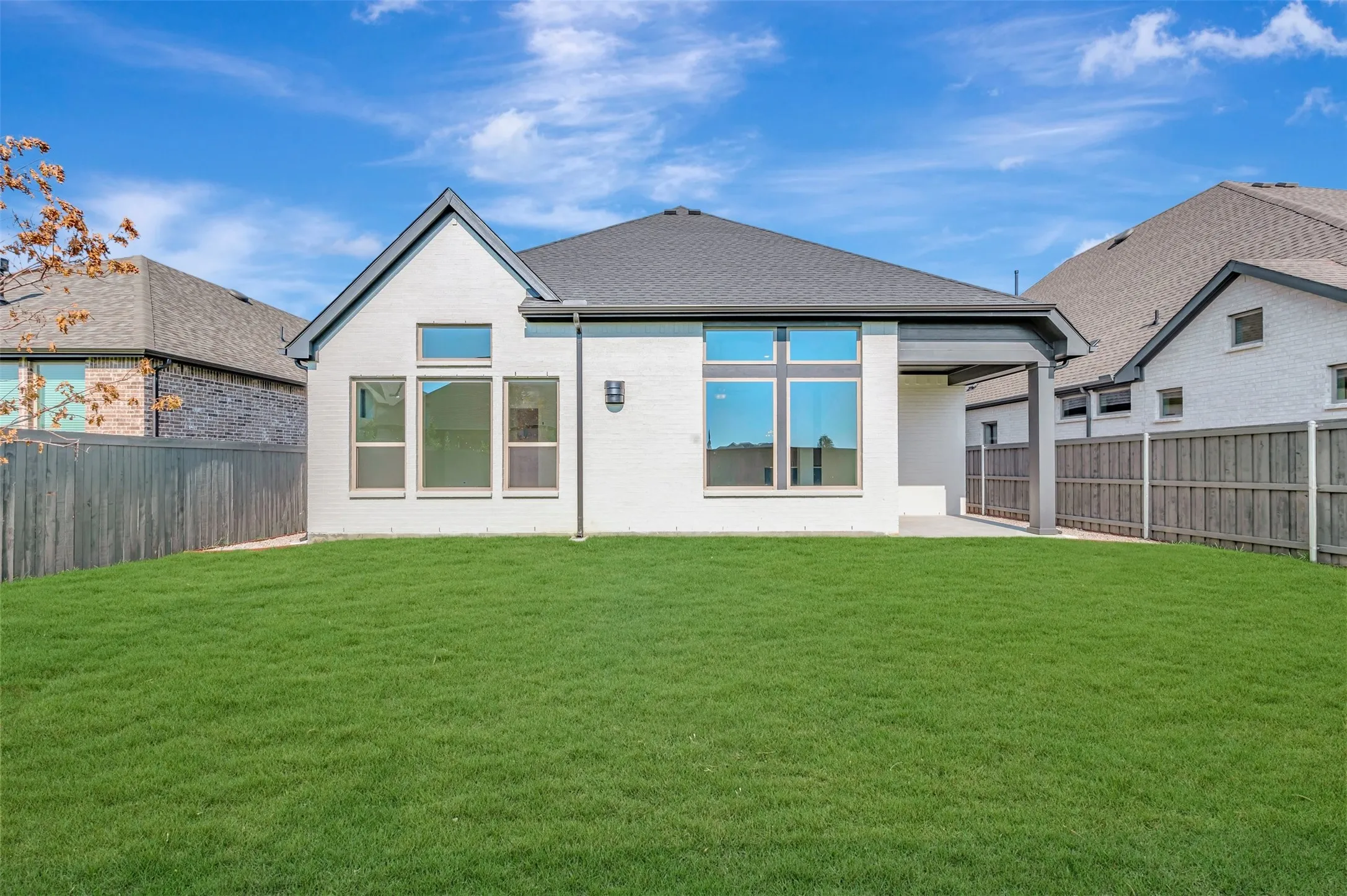 Expansive backyard featuring a manicured lawn, a covered patio, and a privacy fence