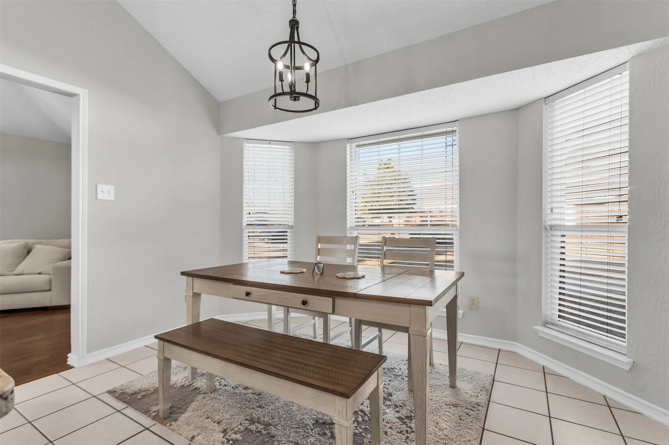 Sunny eat-in dining nook featuring a curved wall of windows overlooking the backyard.