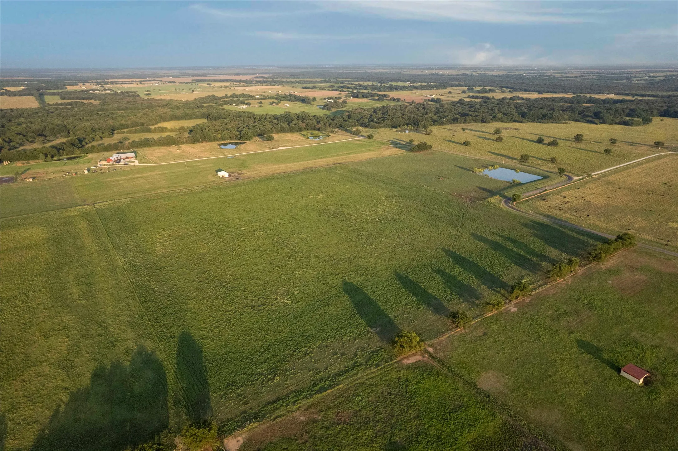 Overview of rural landscape featuring a nearby body of water and abundant farmland