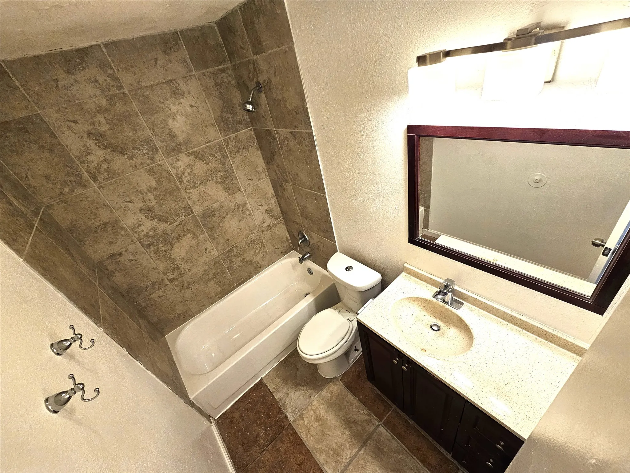 Full bathroom featuring vanity, tiled shower / bath combo, and toilet. It's upstairs in between 2 good size bedrooms.
