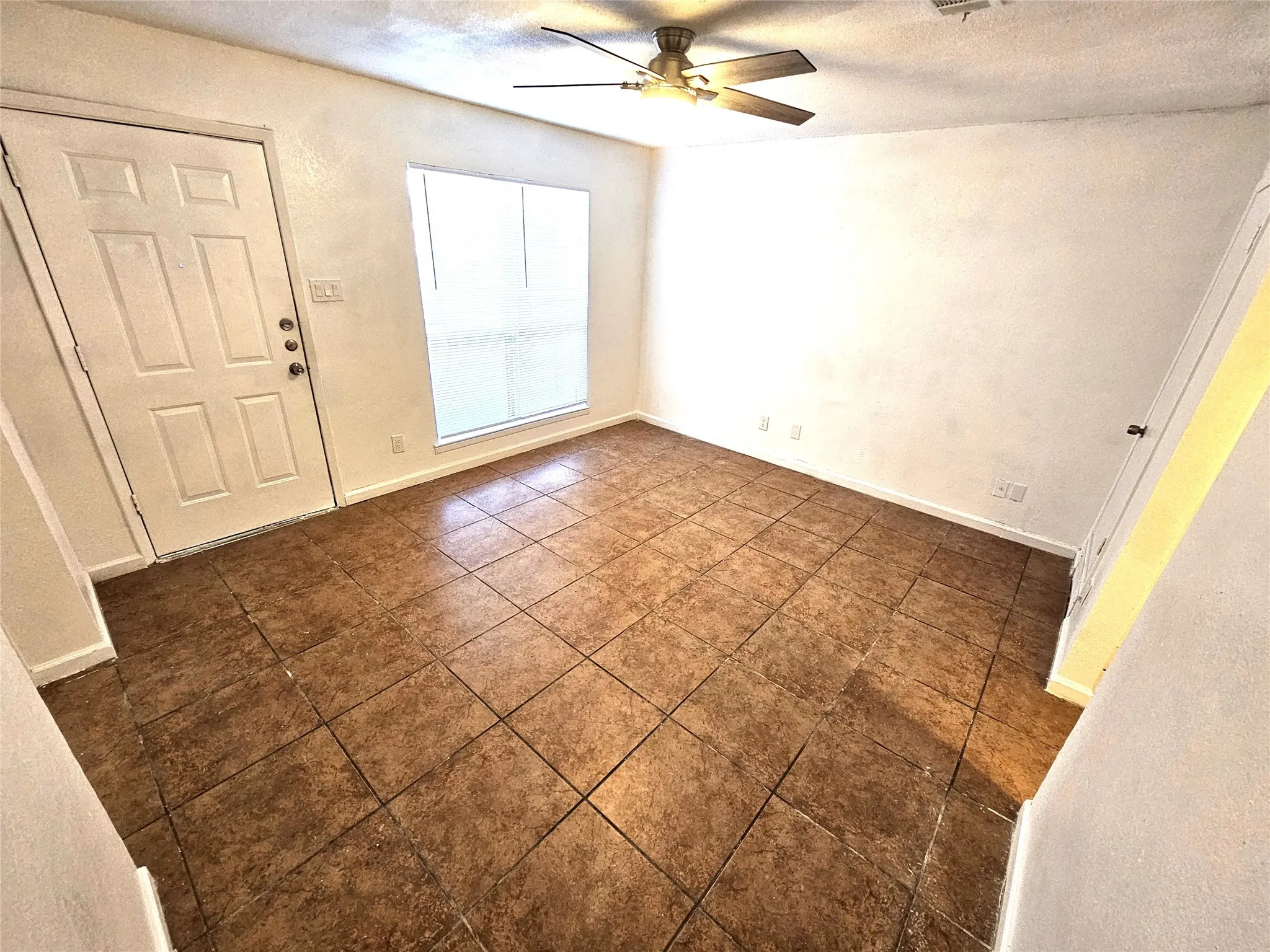 Entrance foyer featuring a textured ceiling and ceiling fan