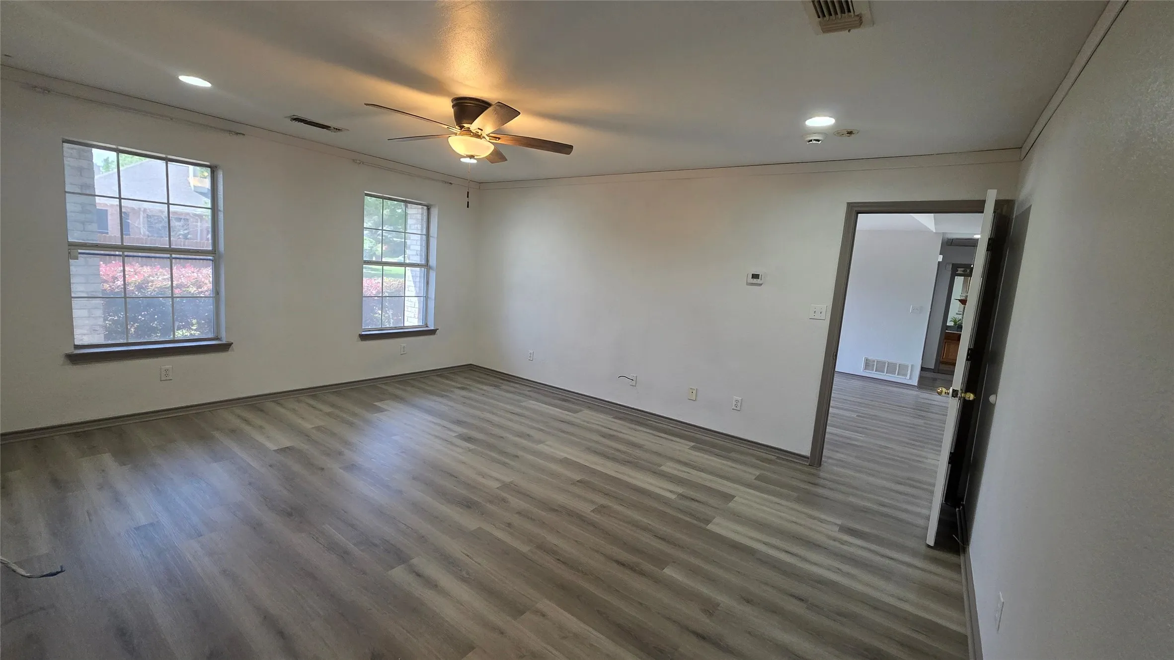 Empty room featuring ceiling fan, crown molding, dark wood-style floors, and recessed lighting