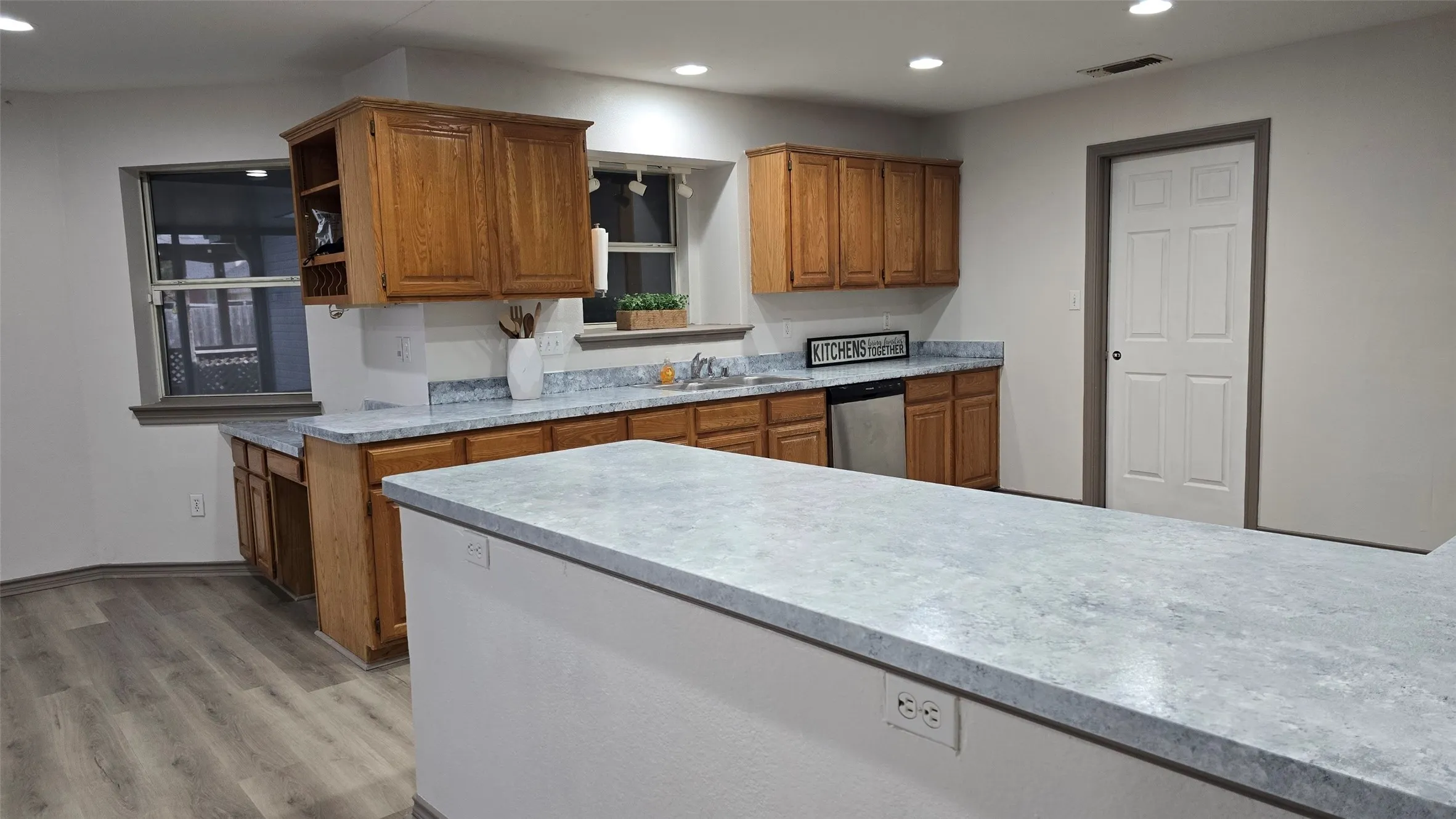 Kitchen with wood finish cabinetry, light wood finished floors, dishwasher, recessed lighting, and open shelves