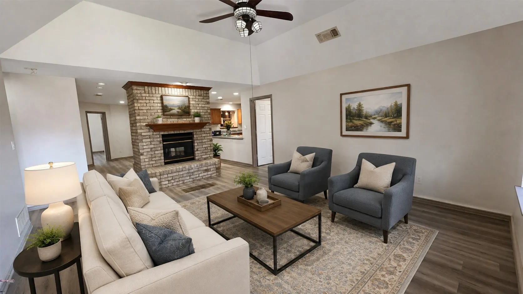 Virtually staged. Spacious living area featuring a brick fireplace with a wood mantel, vaulted ceilings, a ceiling fan, and wood-finish flooring