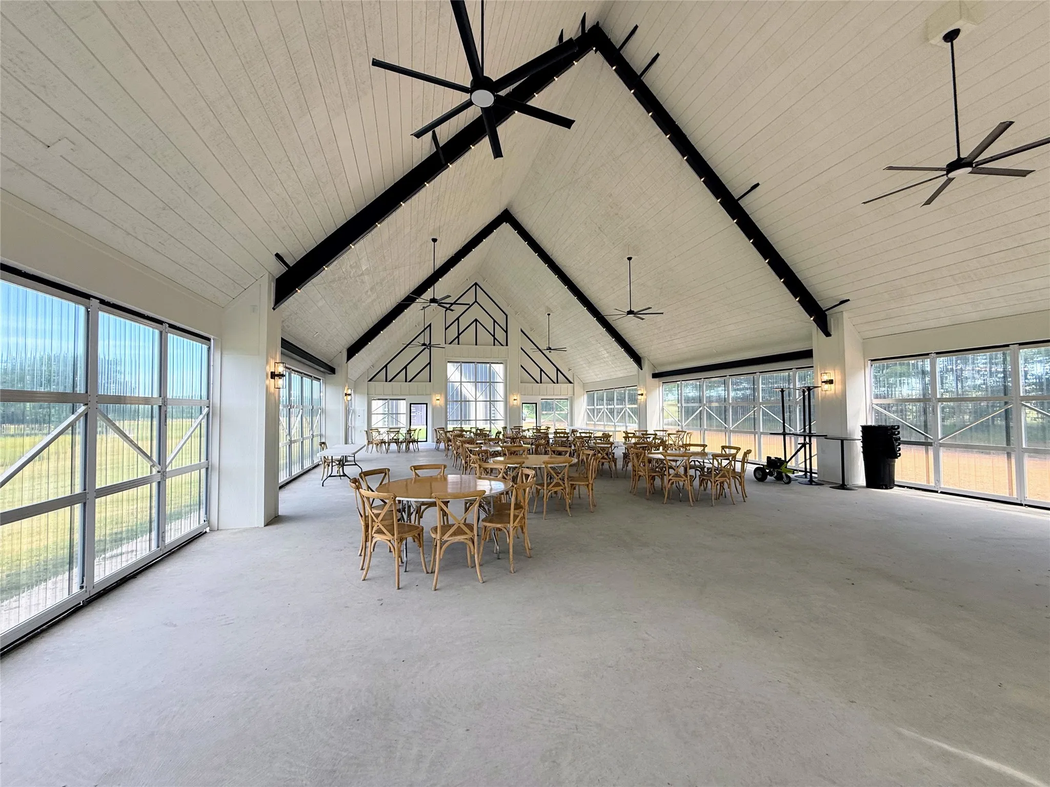 Dining room with high vaulted ceiling, a ceiling fan, and a wooden ceiling with exposed beams