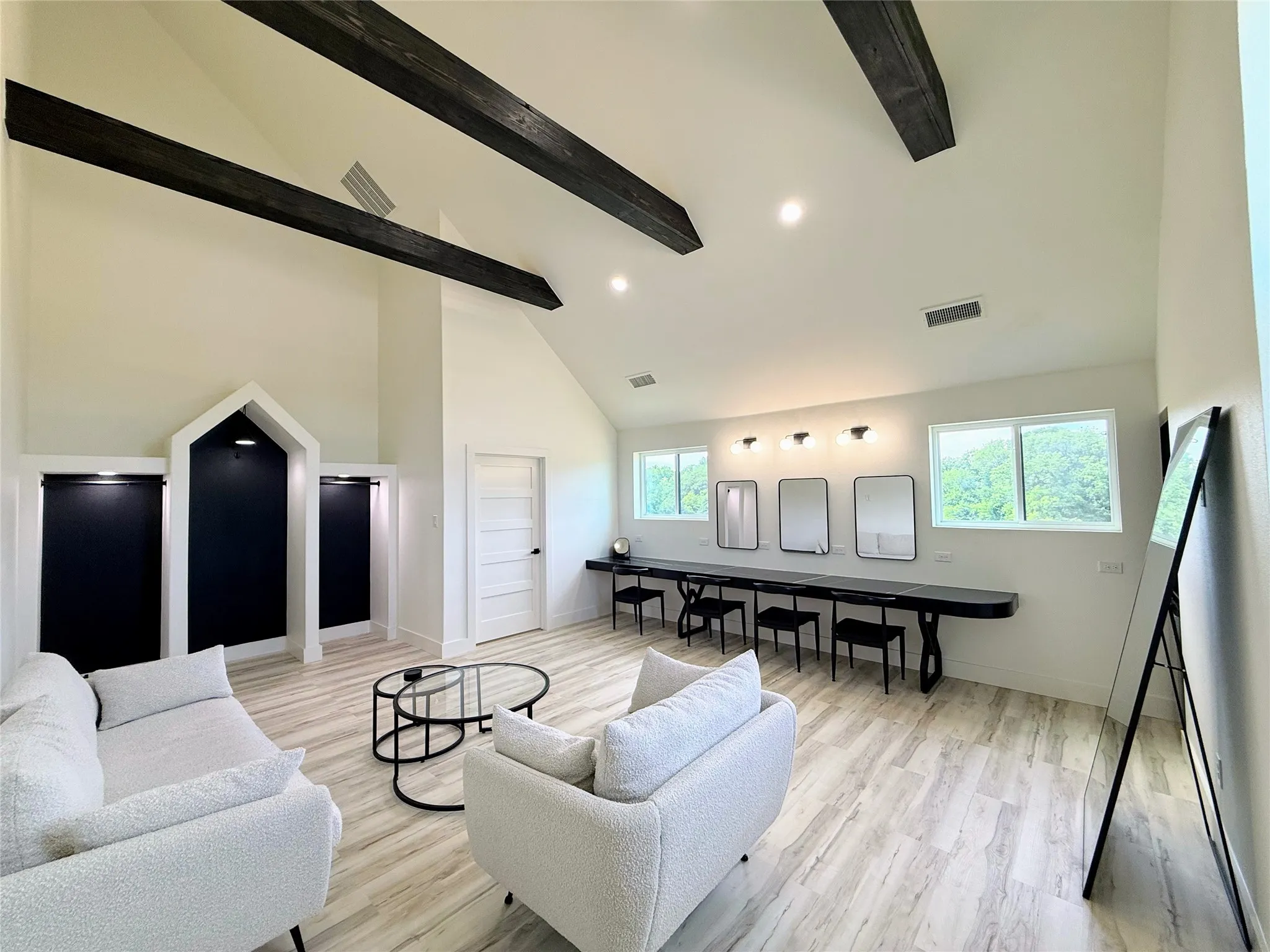 Living room with high vaulted ceiling, light wood-style flooring, beam ceiling, and recessed lighting