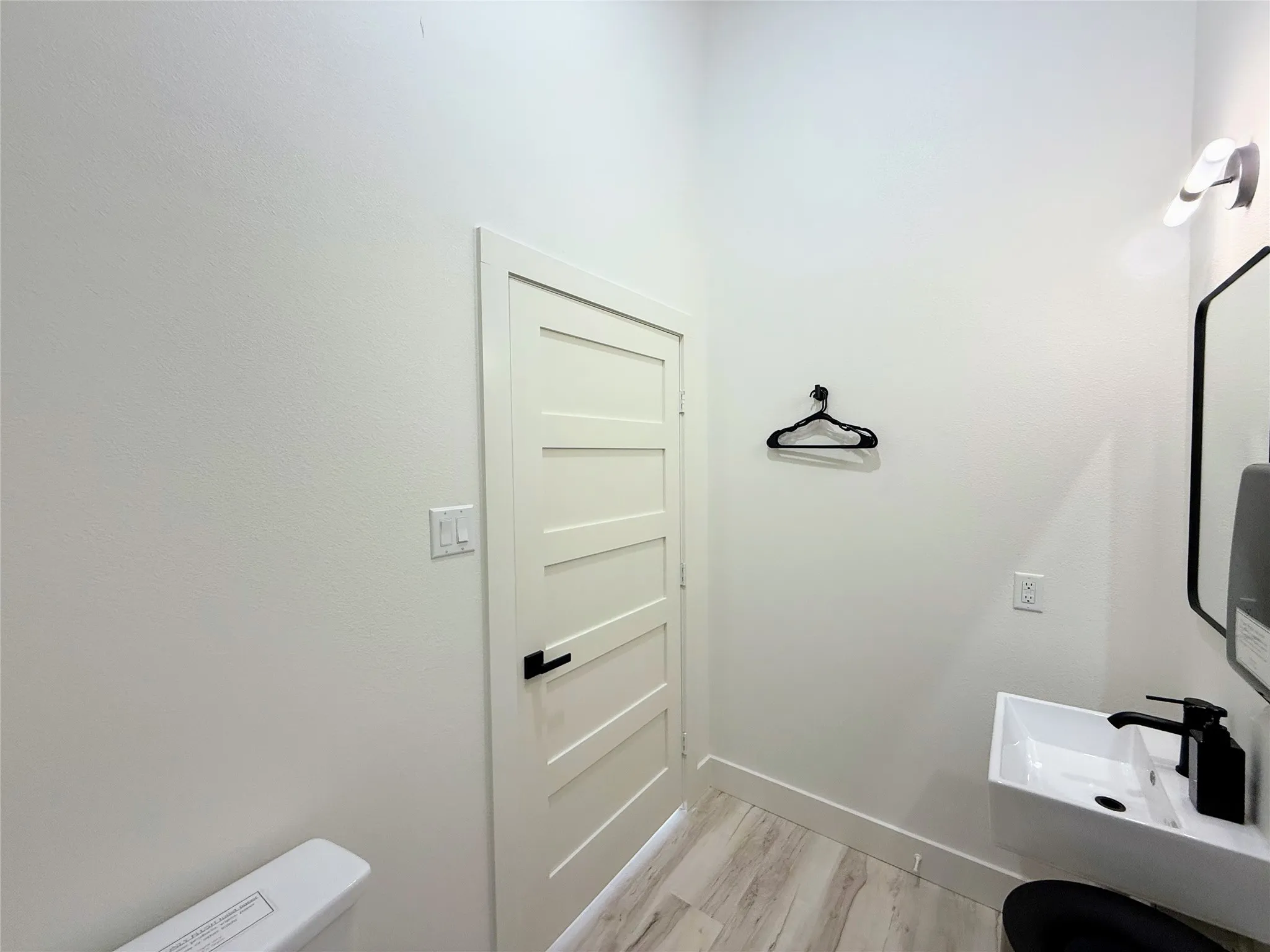 Half bathroom with toilet and light wood-style floors