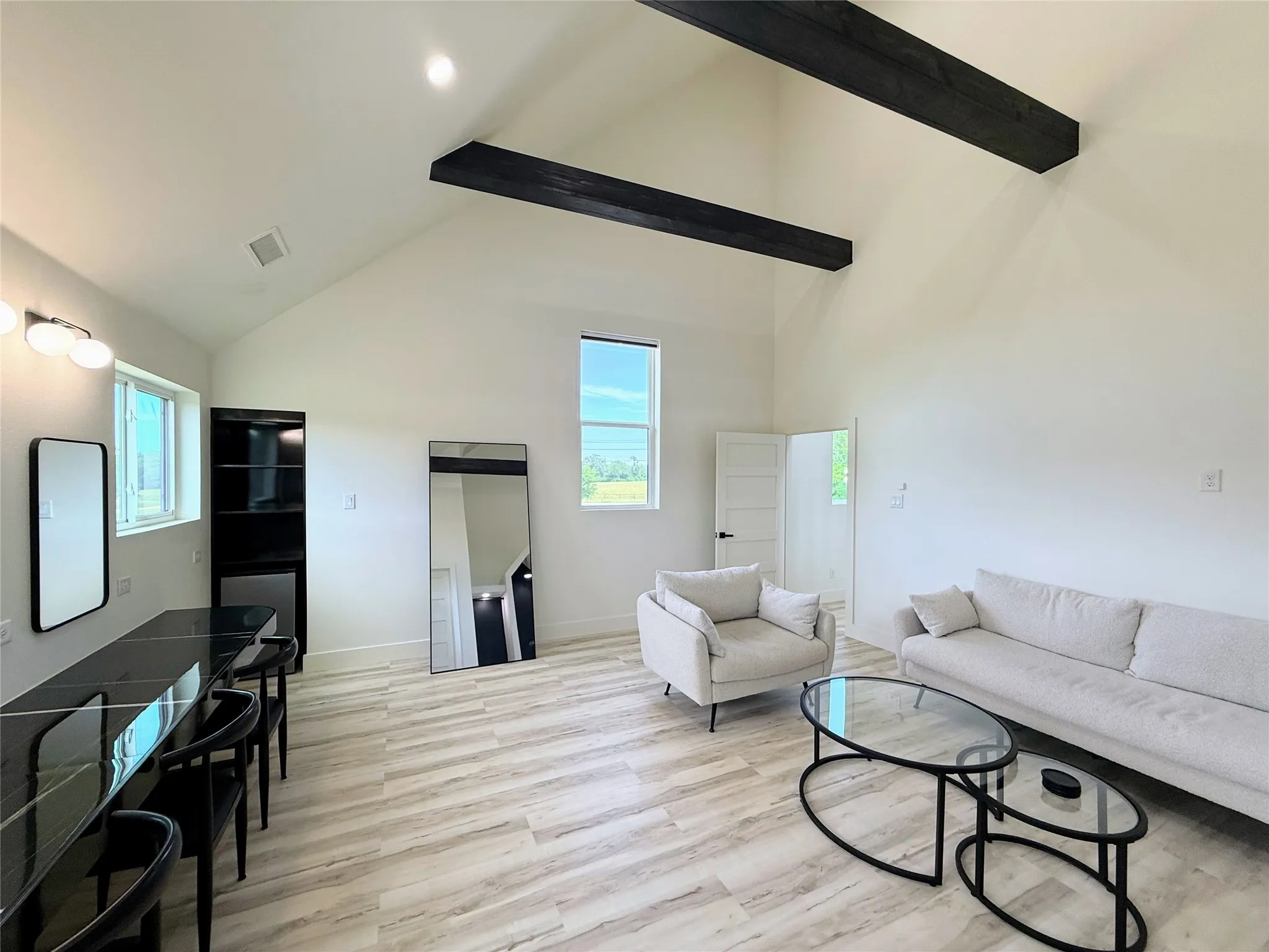 Living room with light wood-style floors and high vaulted ceiling