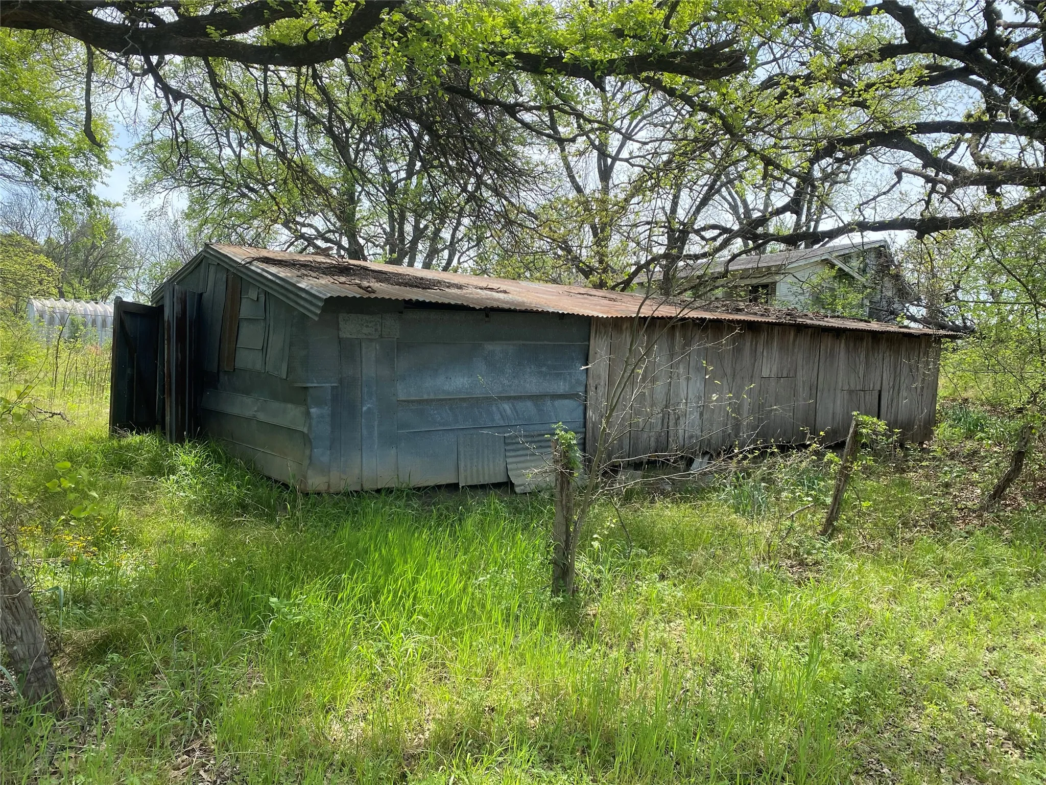Rustic outbuilding featuring corrugated metal siding, wood paneling, and a metal roof