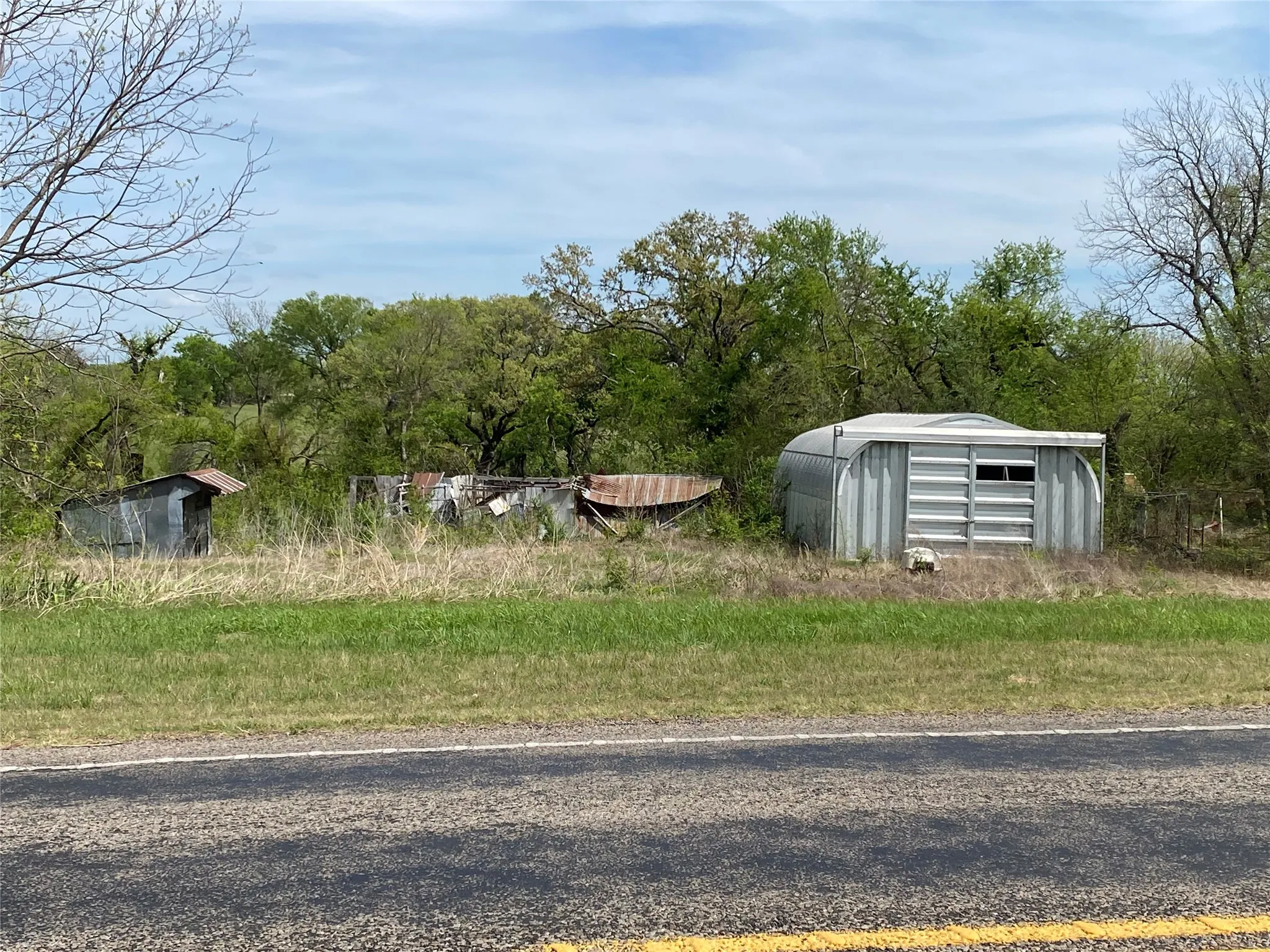 Corrugated metal storage structure with a curved roof