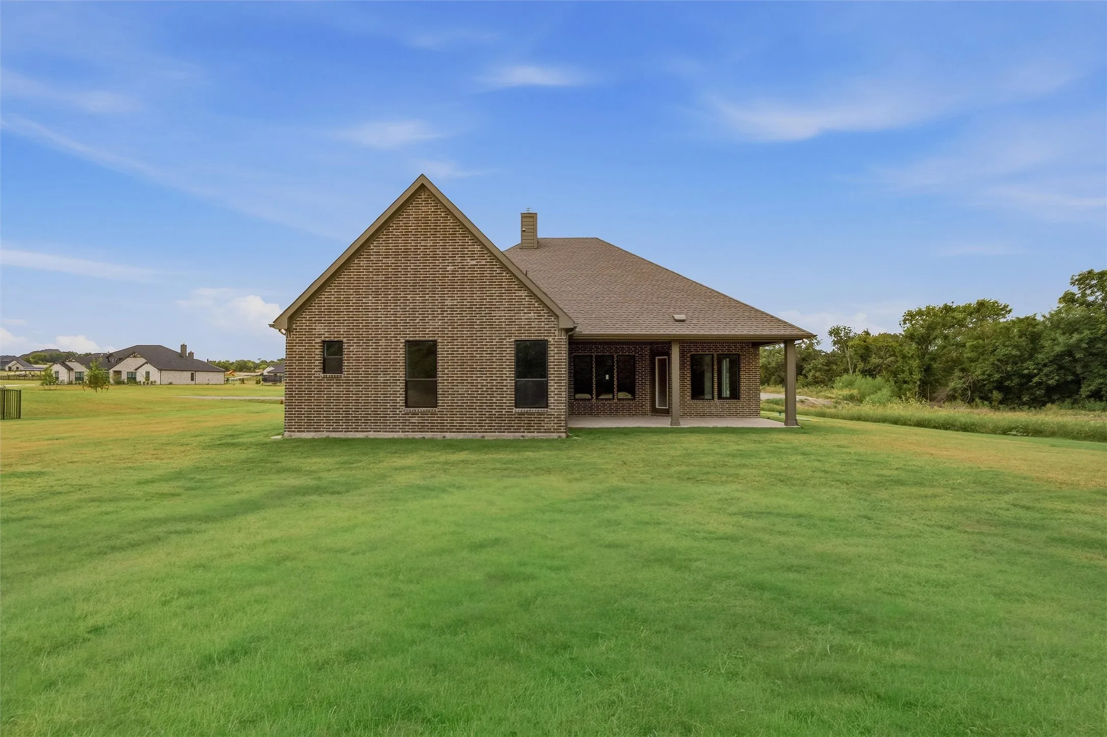 Brick exterior featuring a gabled roof and covered patio
