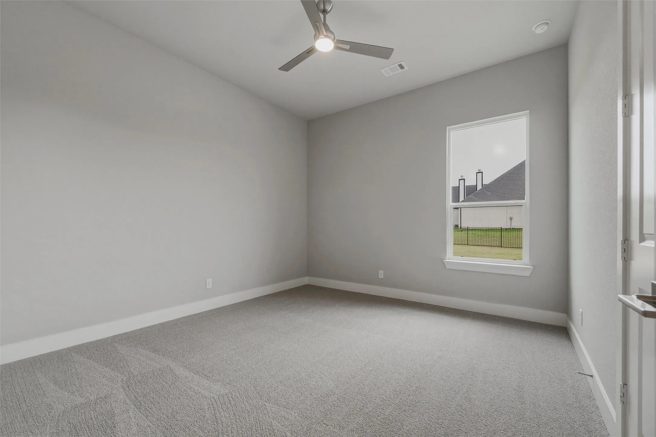 Vaulted ceiling with a ceiling fan, neutral carpet flooring, and a single window