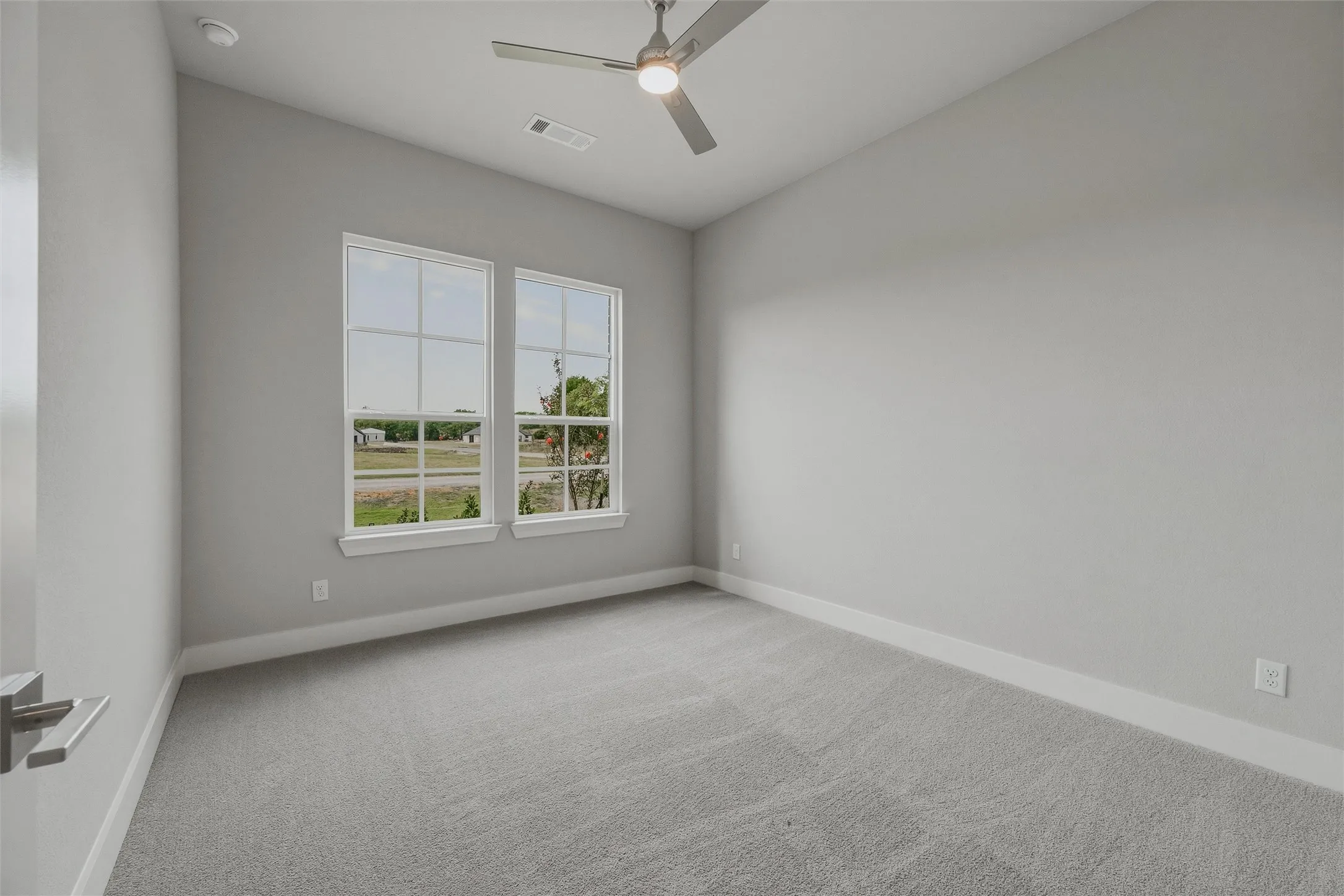 Recessed lighting, ceiling fan, twin windows with white trim, and gray carpet