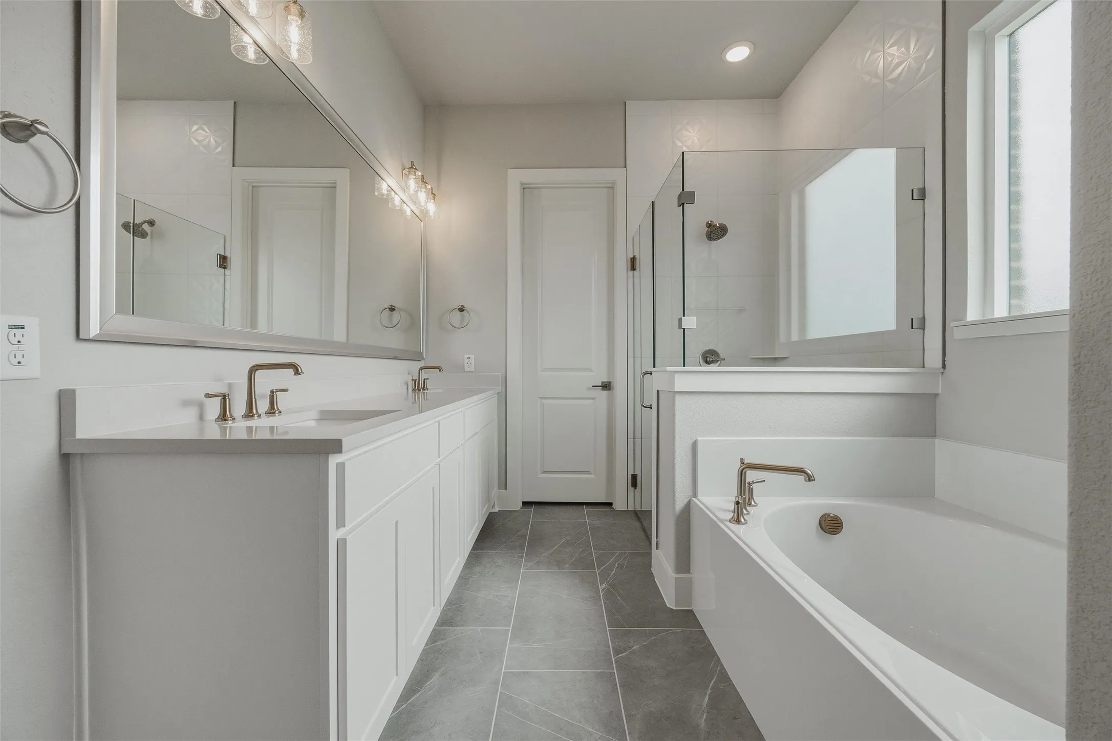 Dual vanity with undermount sinks, bronze finish hardware, and a large framed mirror