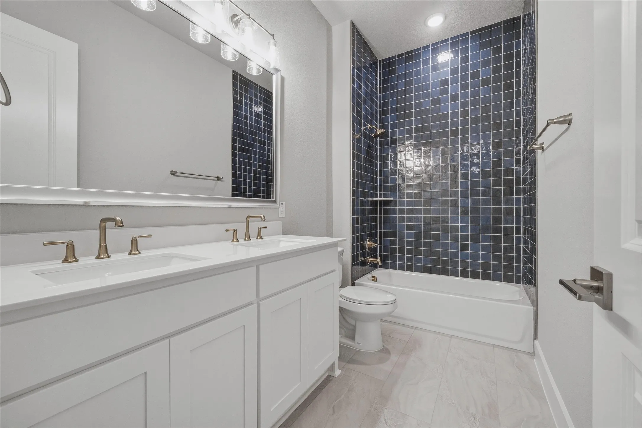 Dual vanity with white shaker-style cabinetry, undermount sinks, and bronze-finish faucets