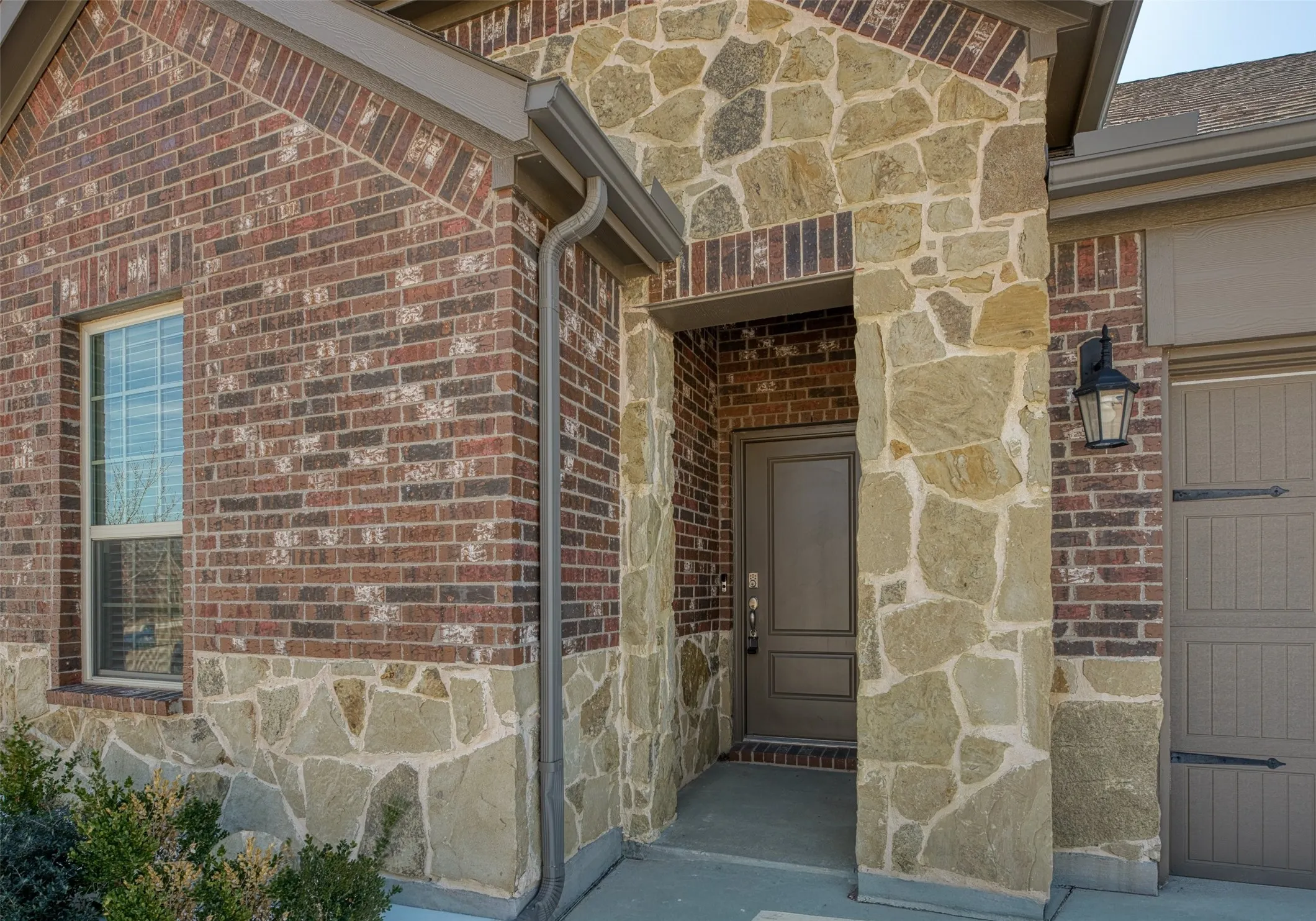 Property entrance with stone siding and brick siding