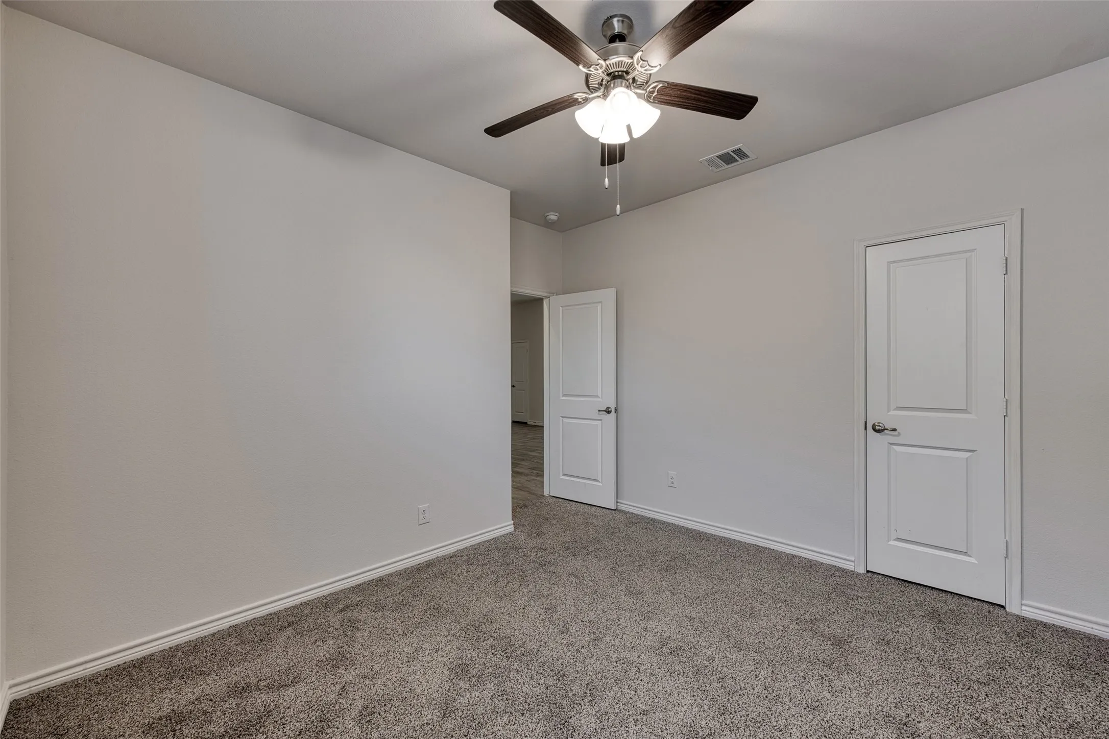 Unfurnished bedroom featuring carpet floors and ceiling fan