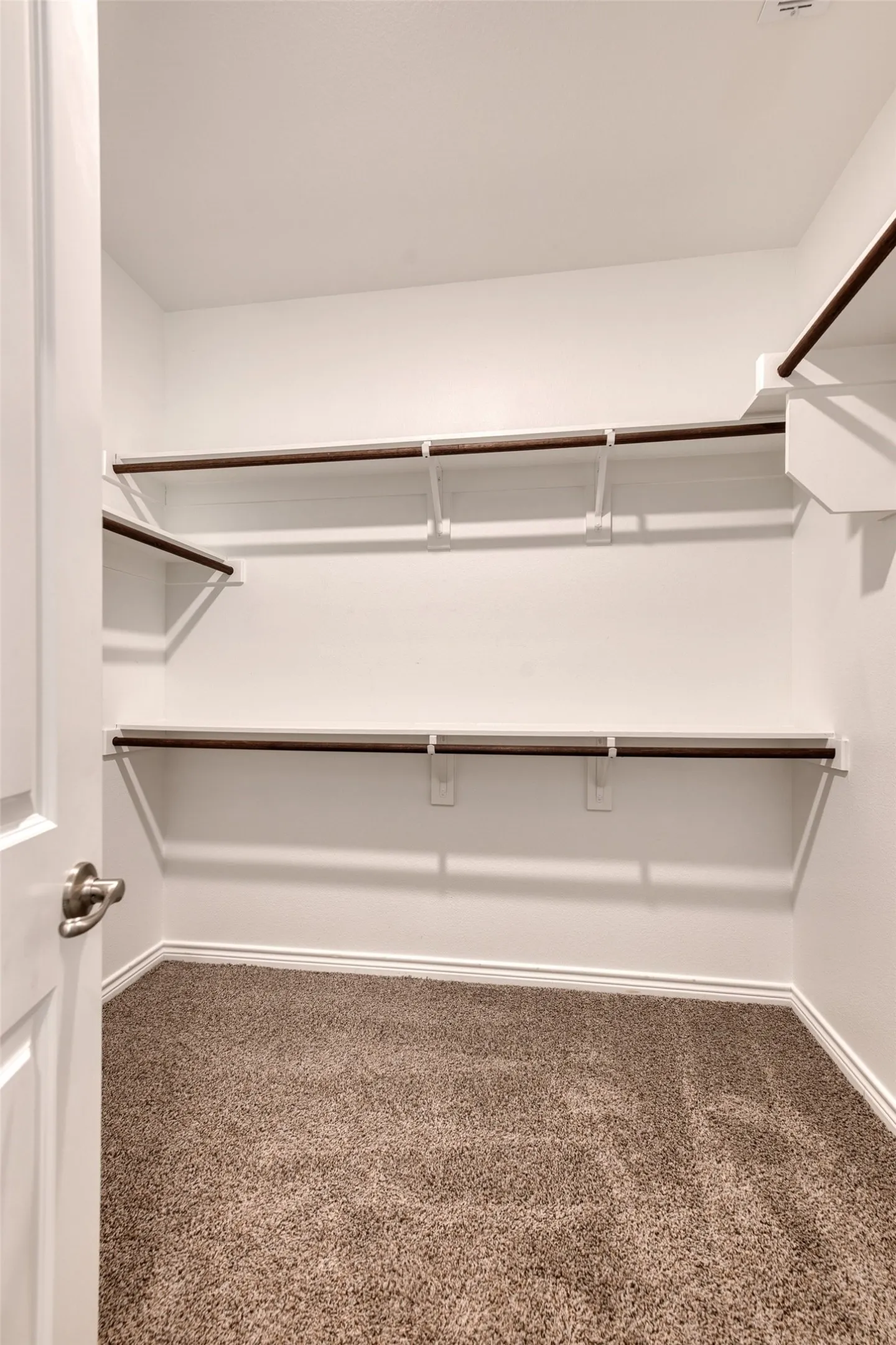 Walk in closet featuring dark carpet