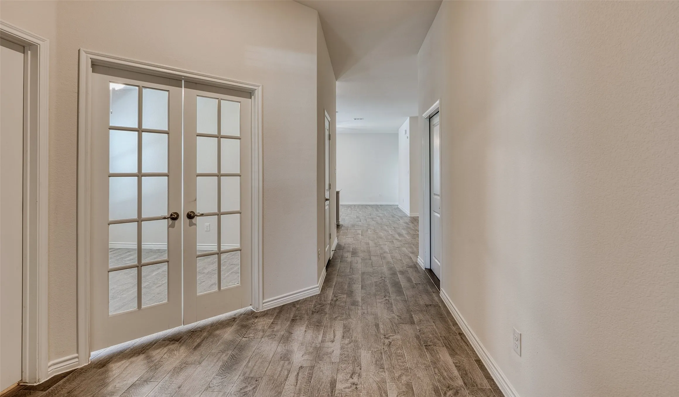 Hall with wood finished floors and french doors