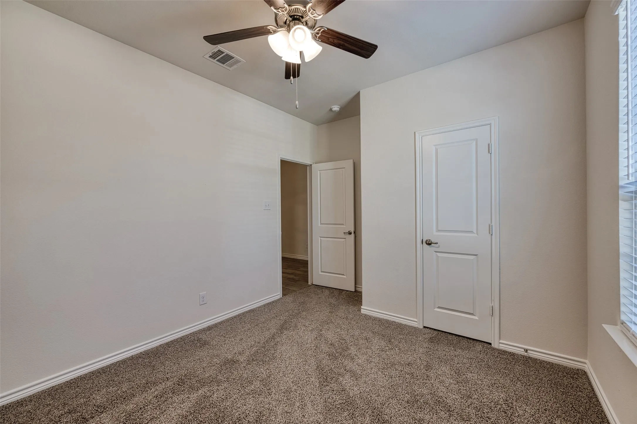 Unfurnished bedroom featuring carpet flooring and a ceiling fan