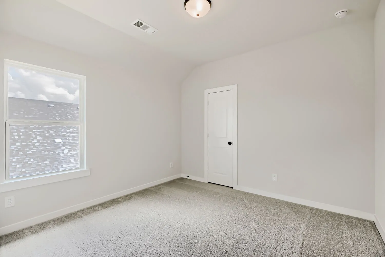 Bedroom featuring neutral wall paint, gray carpeting, white trim, and a prominent window