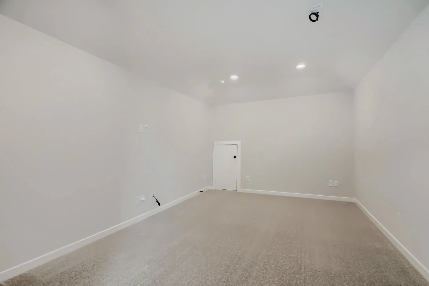 Spacious room featuring neutral carpeting, light-toned walls, and recessed lighting fixtures