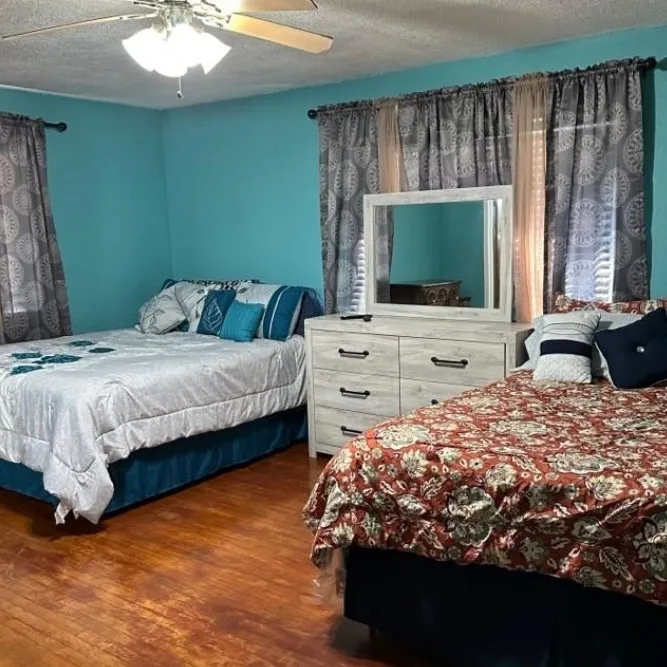 Bedroom with dark wood-type flooring, a textured ceiling, and a ceiling fan