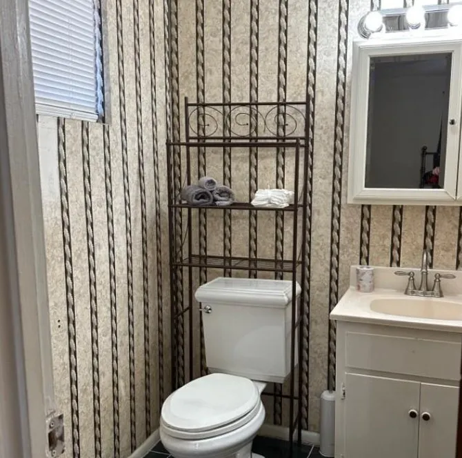 Half bathroom featuring vanity and toilet