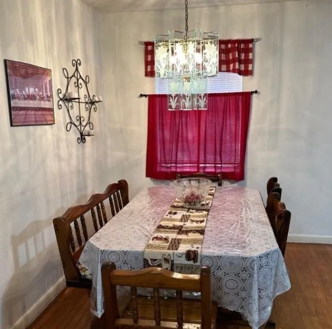 Dining room with hanging lights and dark wood-type flooring