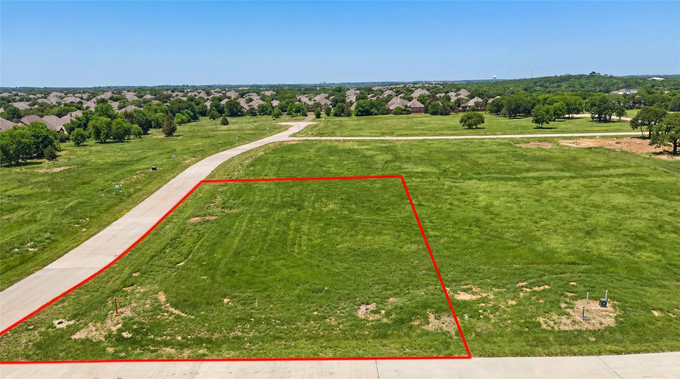 This is an aerial photograph of Lot 10 Block J and was captured in February. It has been digitally enhanced to emphasize the presence of leaves and grass.