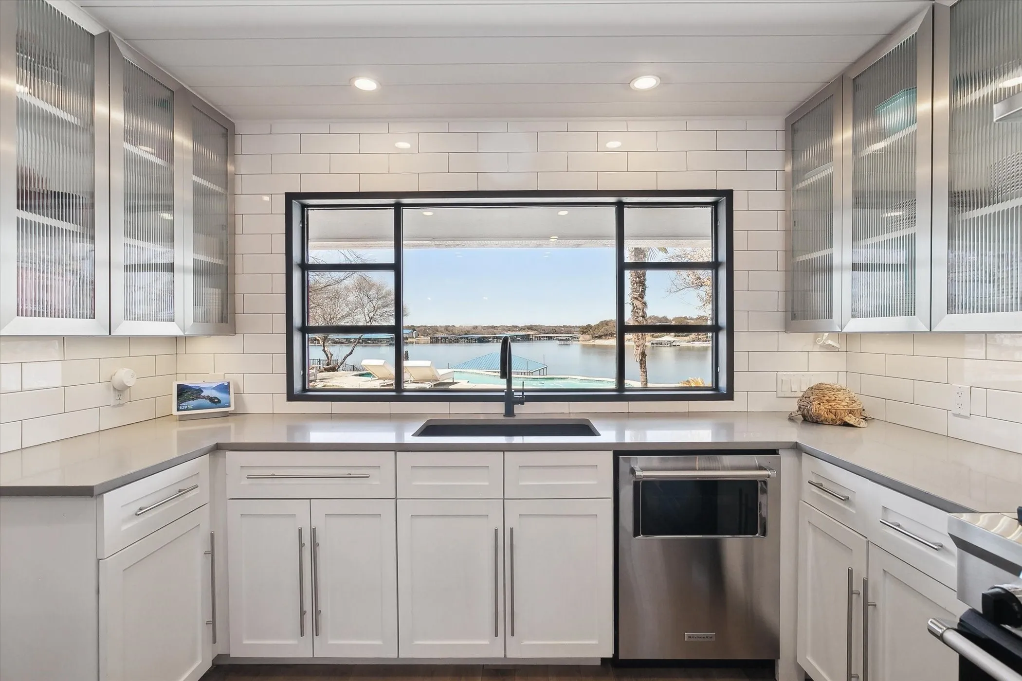 Kitchen featuring white cabinets with glass inserts, decorative backsplash and gorgeous views!