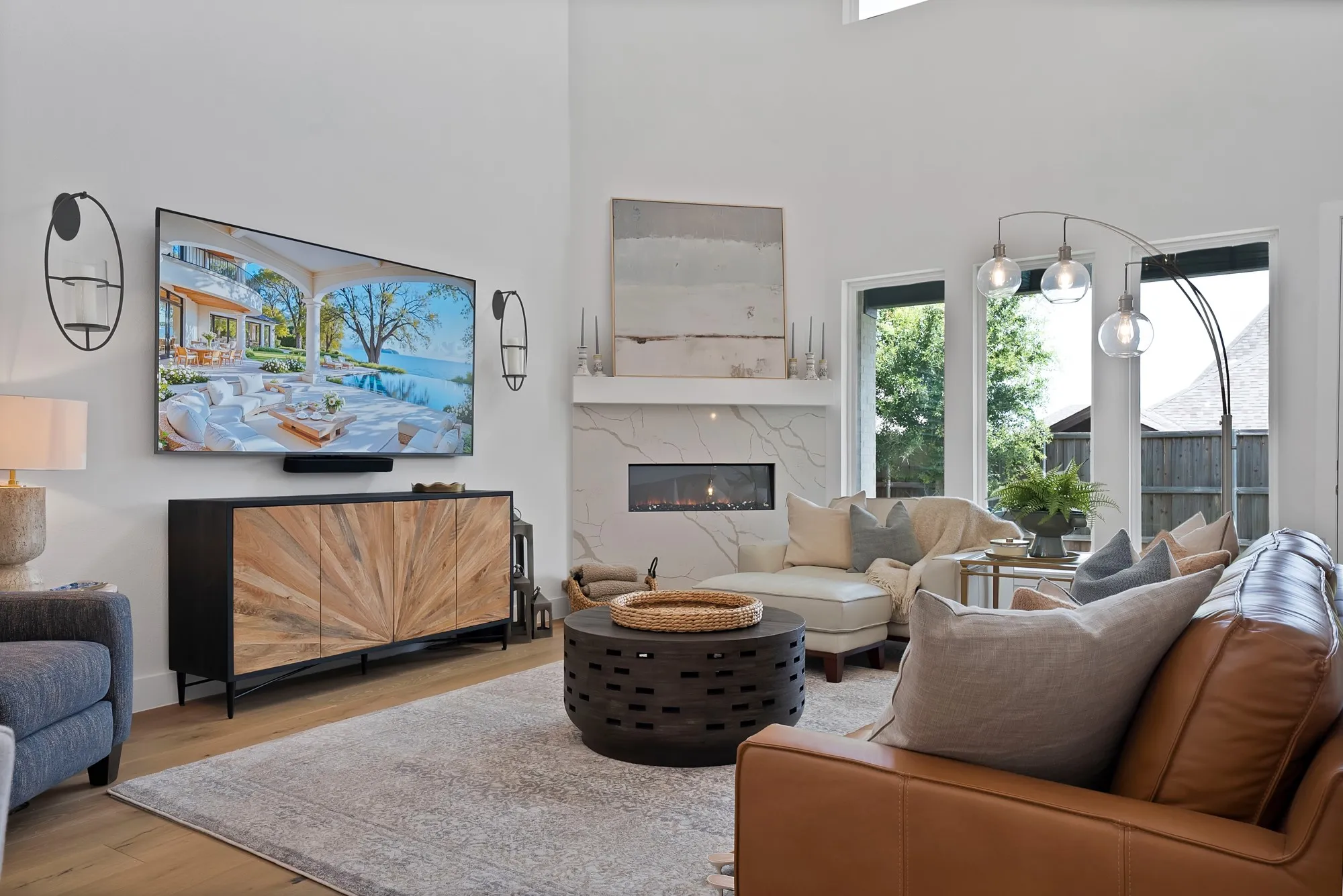 Spacious living area featuring a vaulted ceiling, a linear gas fireplace with a stone surround, and wood-finish flooring
