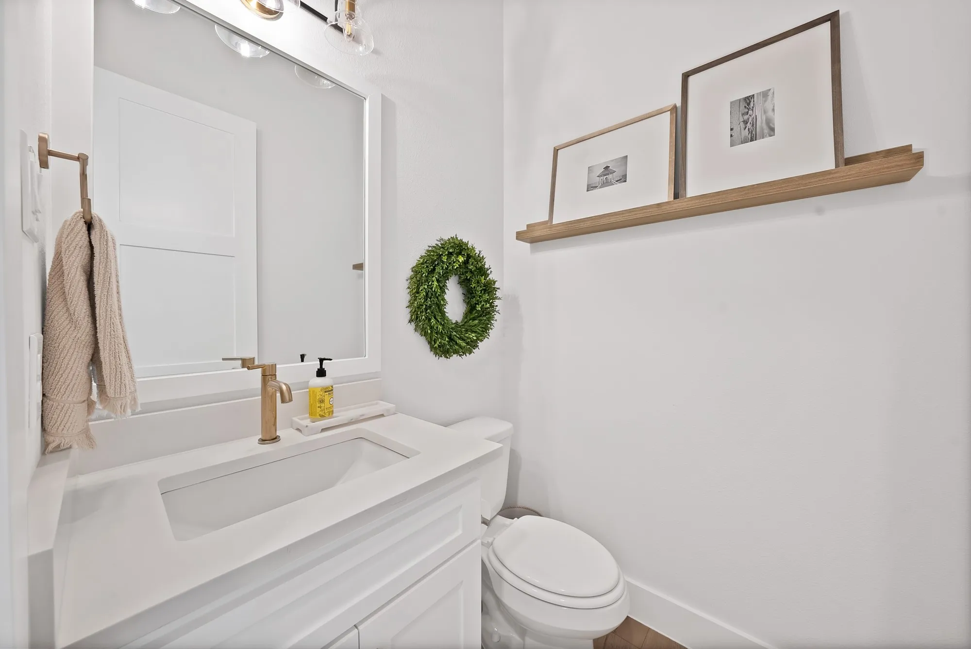 White vanity with integrated rectangular sink and brass-finish faucet