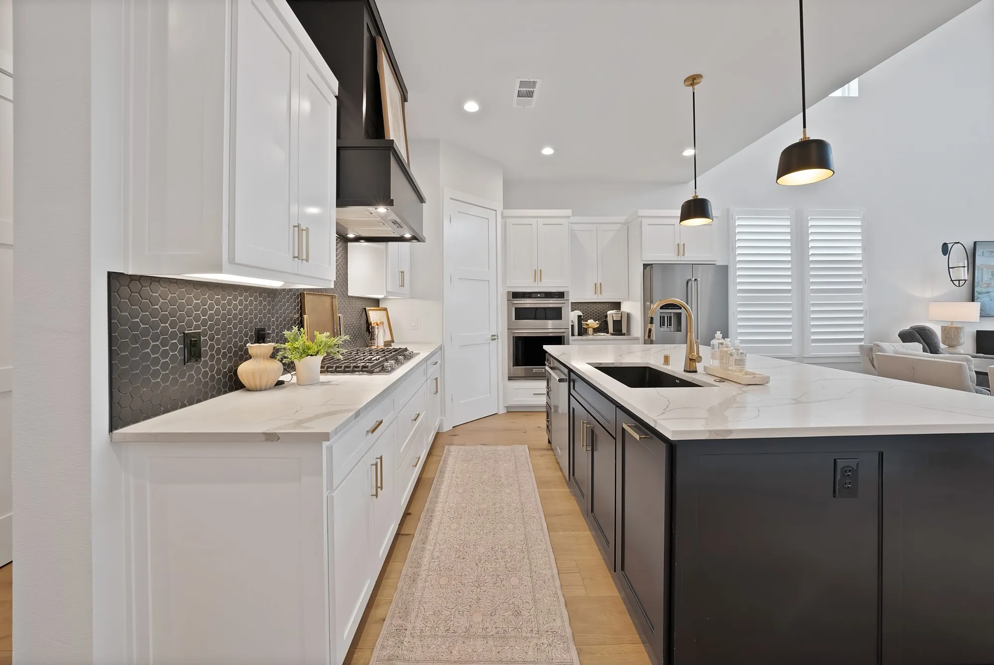 Modern kitchen featuring an expansive center island with a black base and a light-toned countertop