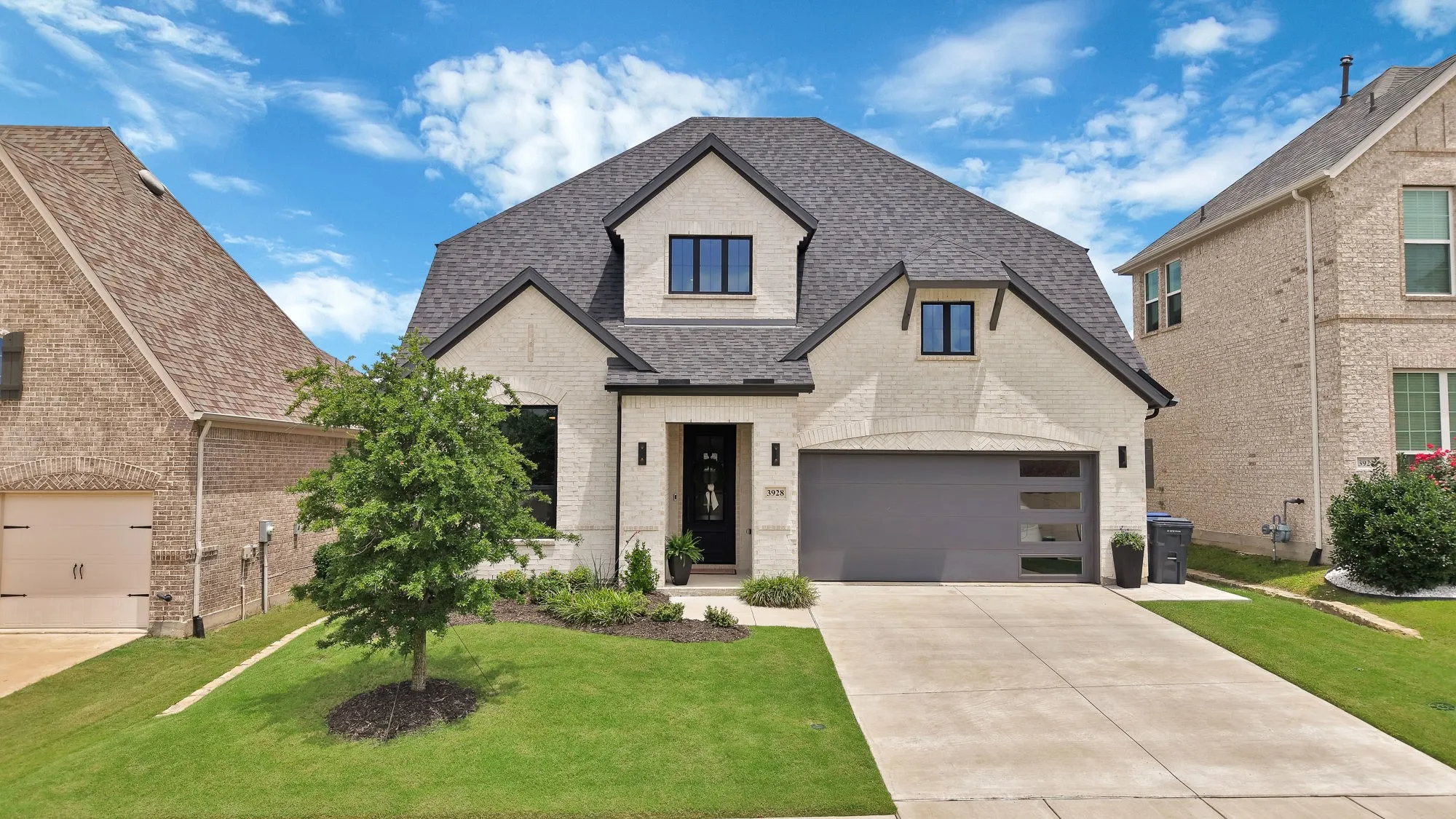 Contemporary-style residence featuring a light brick facade and dark trim accents