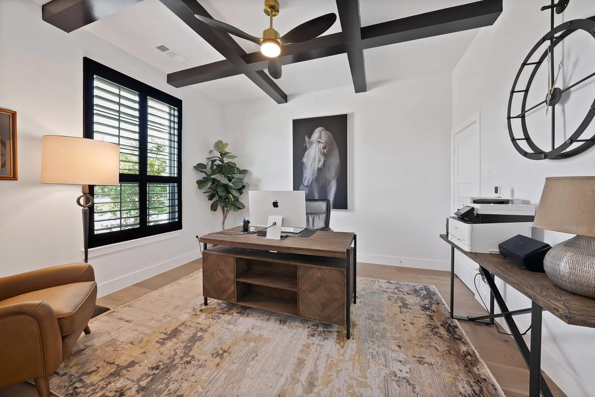 Room featuring light wood-finish flooring, white walls, and a white ceiling with dark exposed beams
