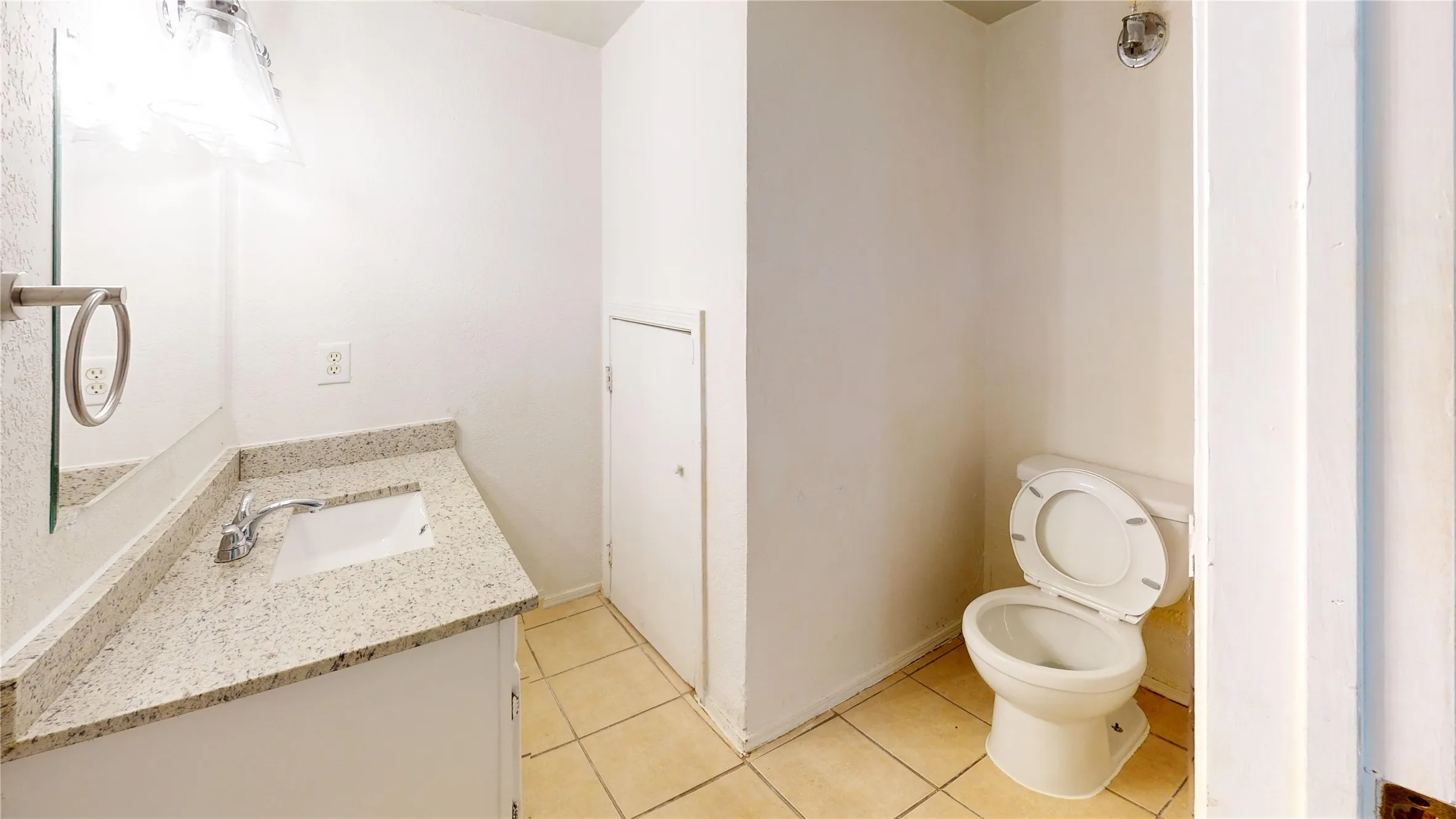 Half bath featuring vanity and light tile patterned floors
