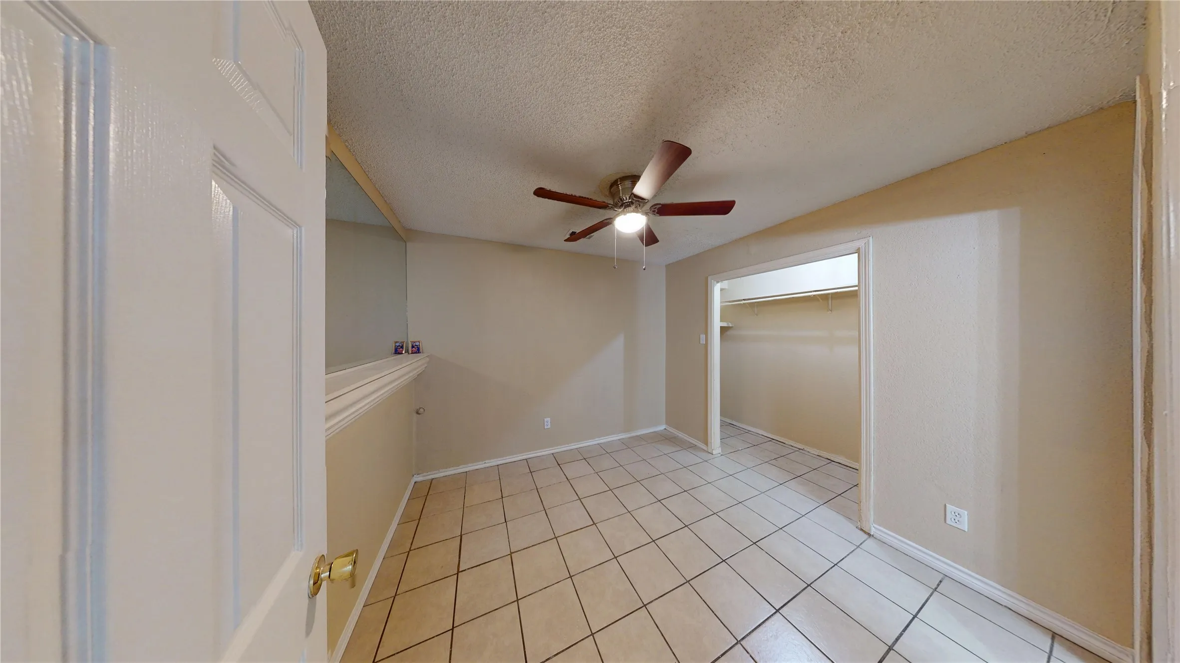 Unfurnished room with a textured ceiling, a ceiling fan, and light tile patterned flooring