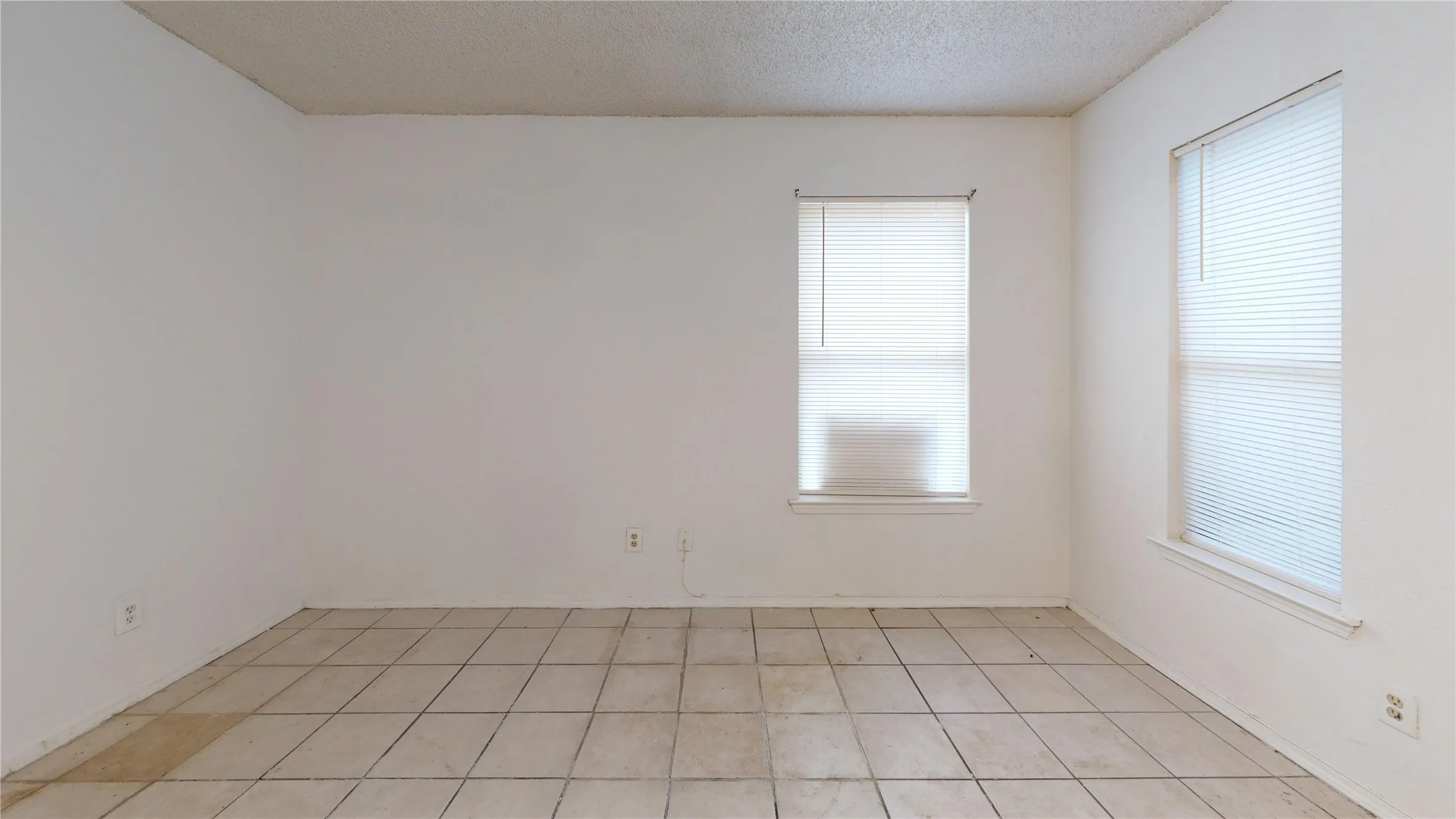 Spare room featuring a textured ceiling and light tile patterned flooring