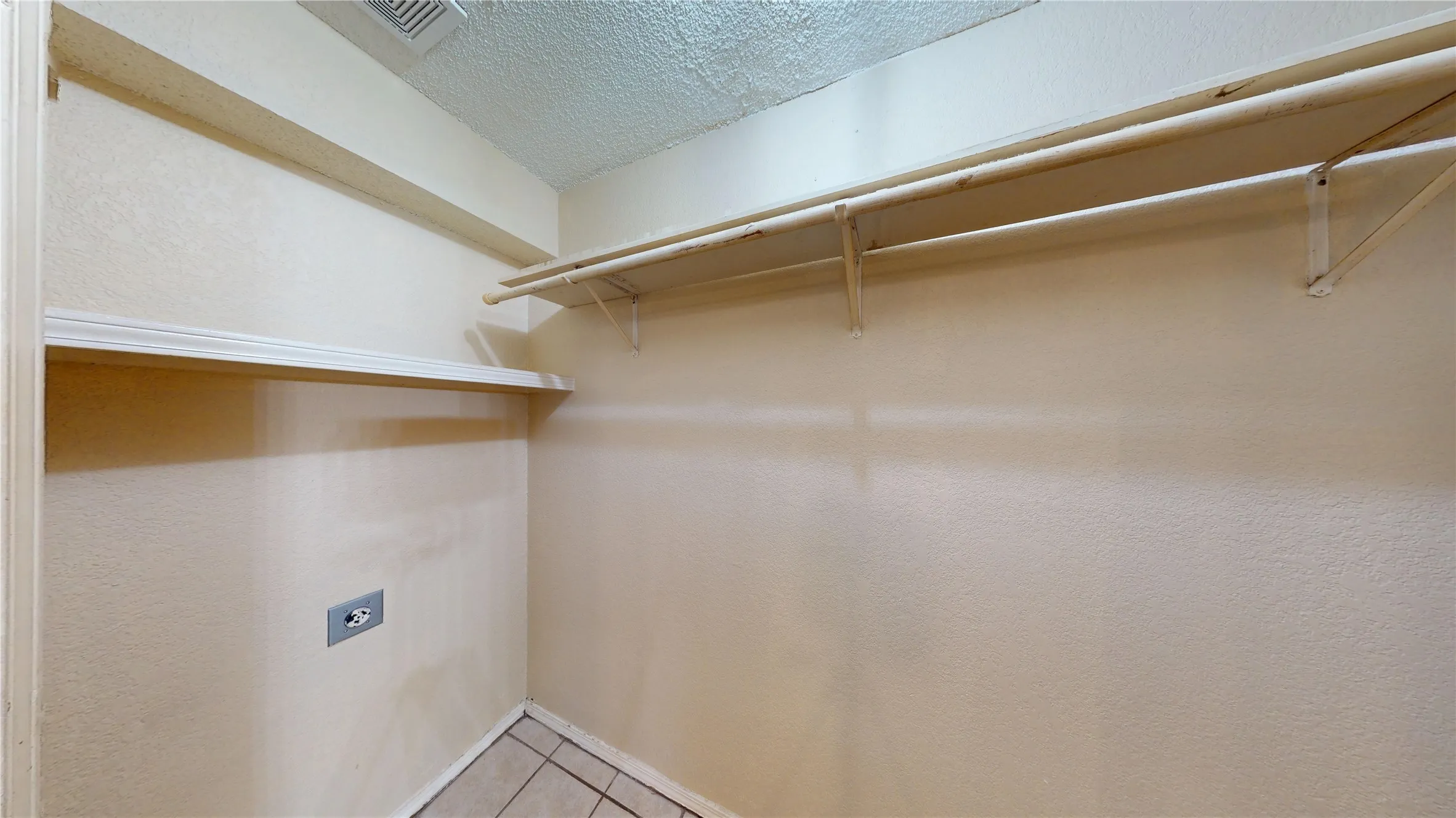 Spacious closet with light tile patterned floors