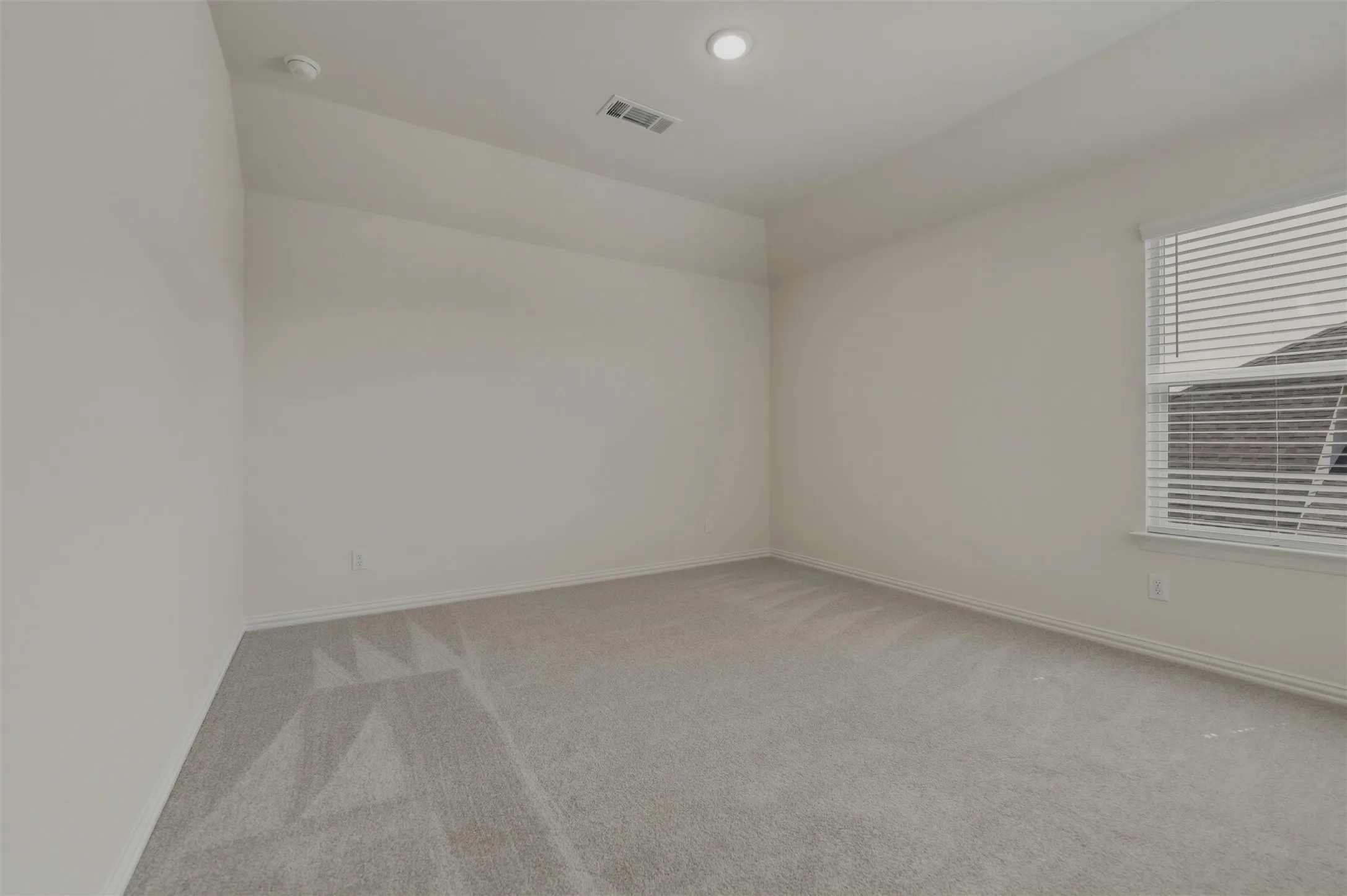 Recessed ceiling lighting, window with blinds, carpeted flooring, and white painted walls