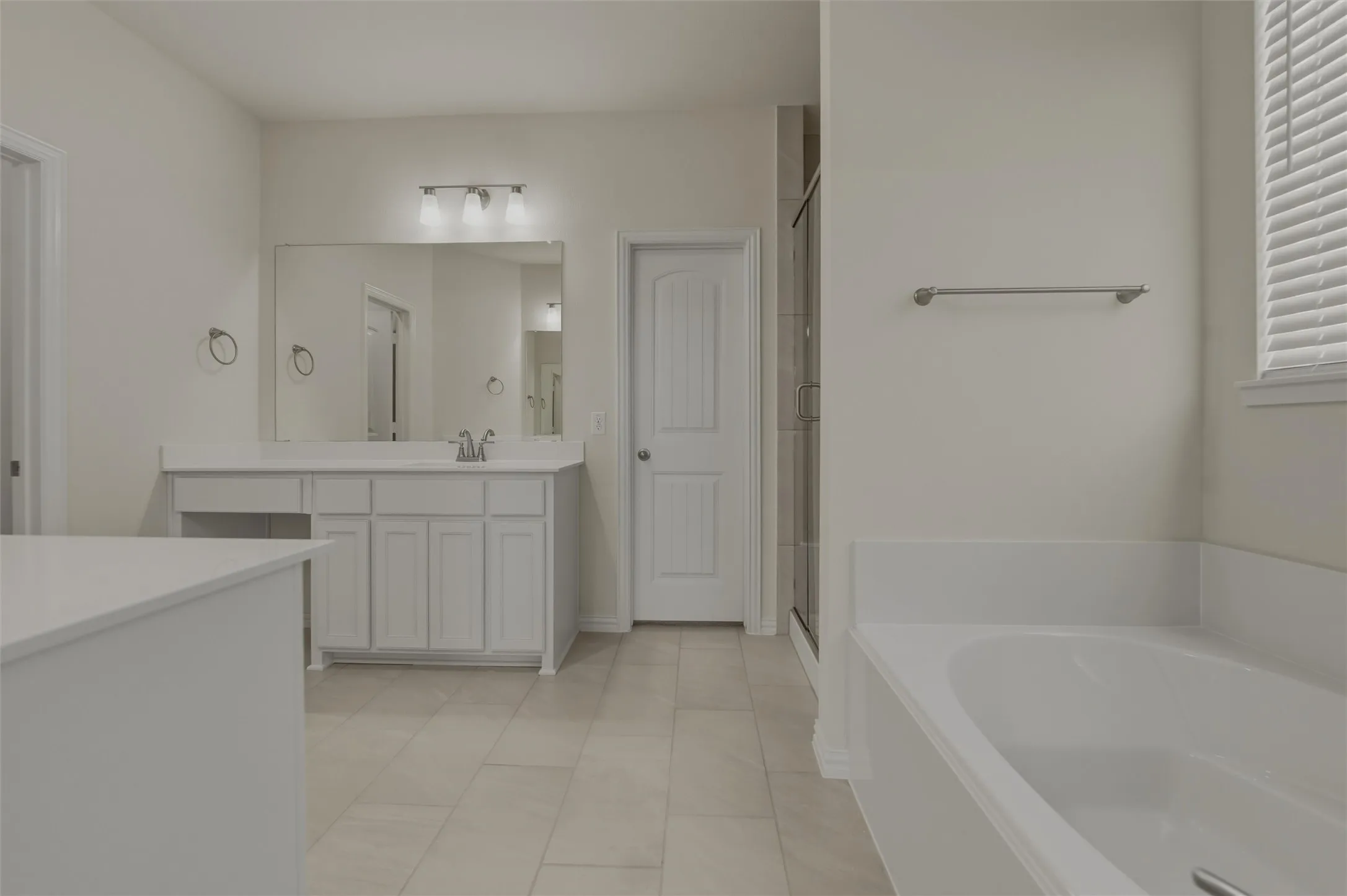 White shaker-style vanity with a single sink and large mirror