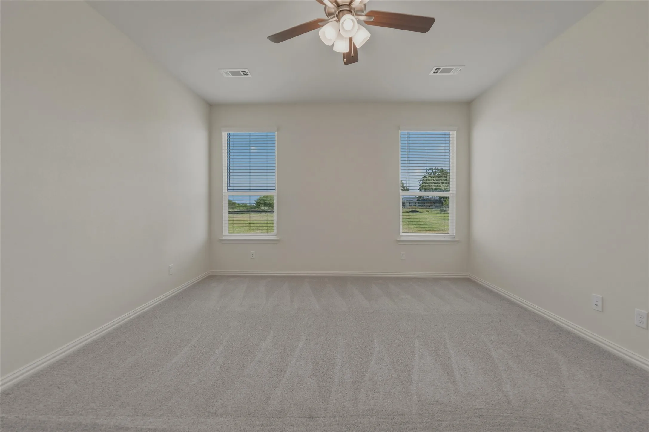 Recessed lighting, ceiling fan with light fixture, two windows, wall-to-wall carpeting