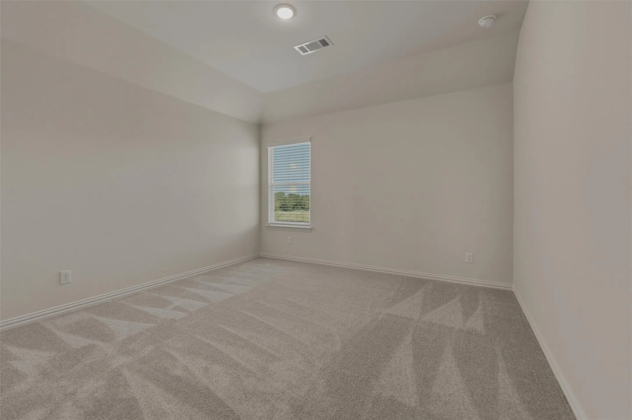 Recessed lighting, neutral paint, light gray carpeting, window with blinds
