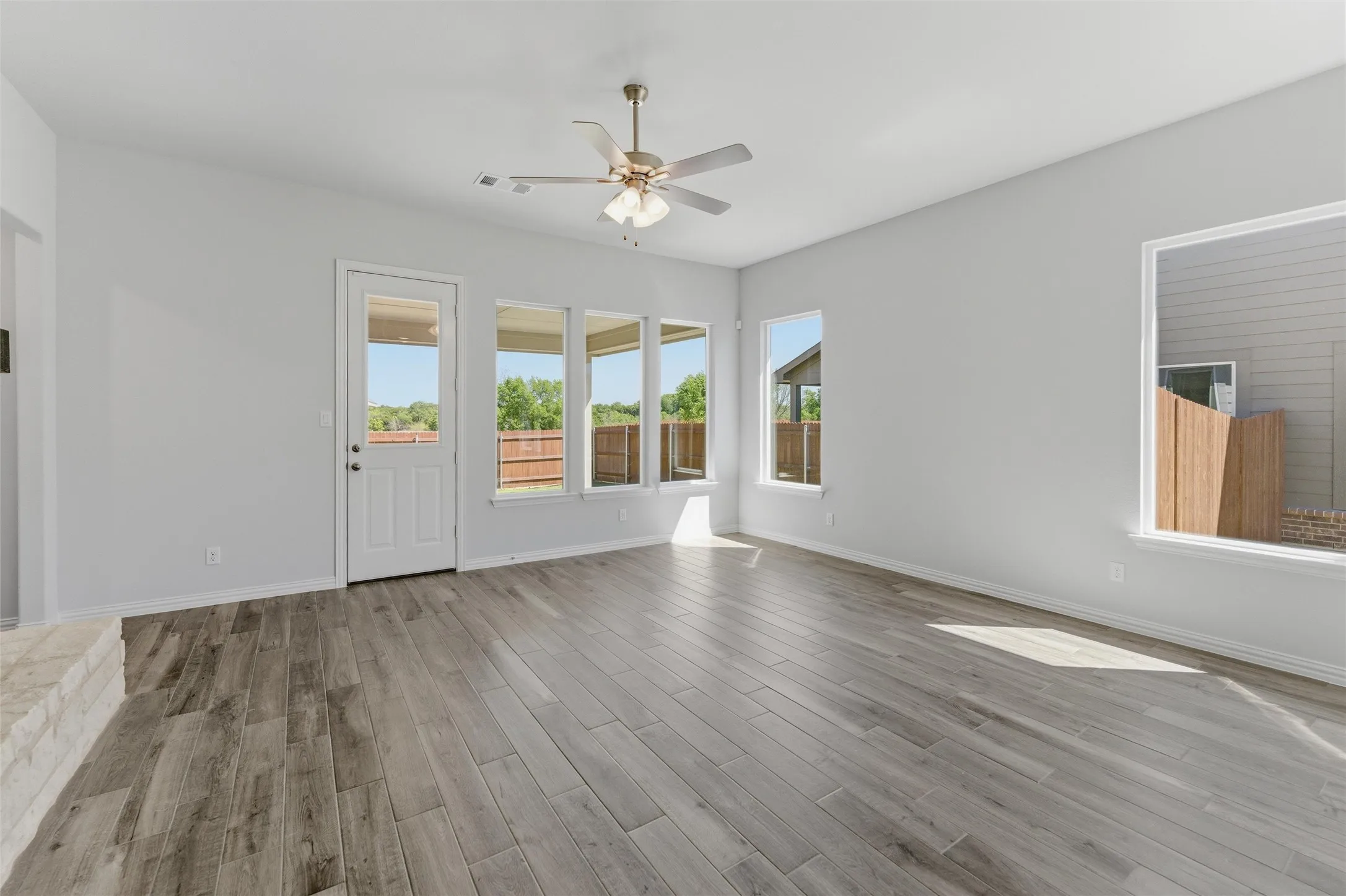 Unfurnished living room featuring ceiling fan and light wood-type flooring