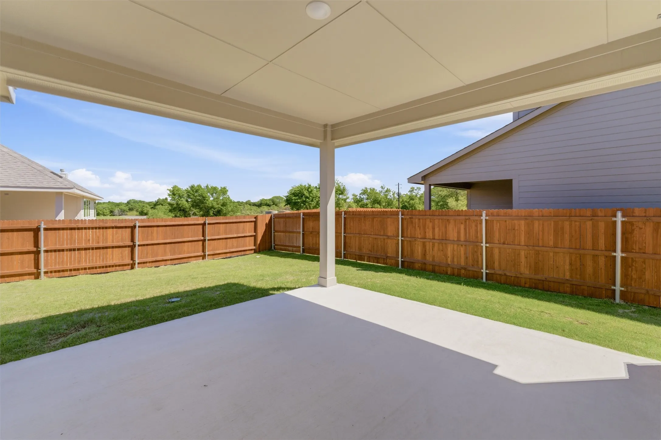 Fenced backyard with a patio