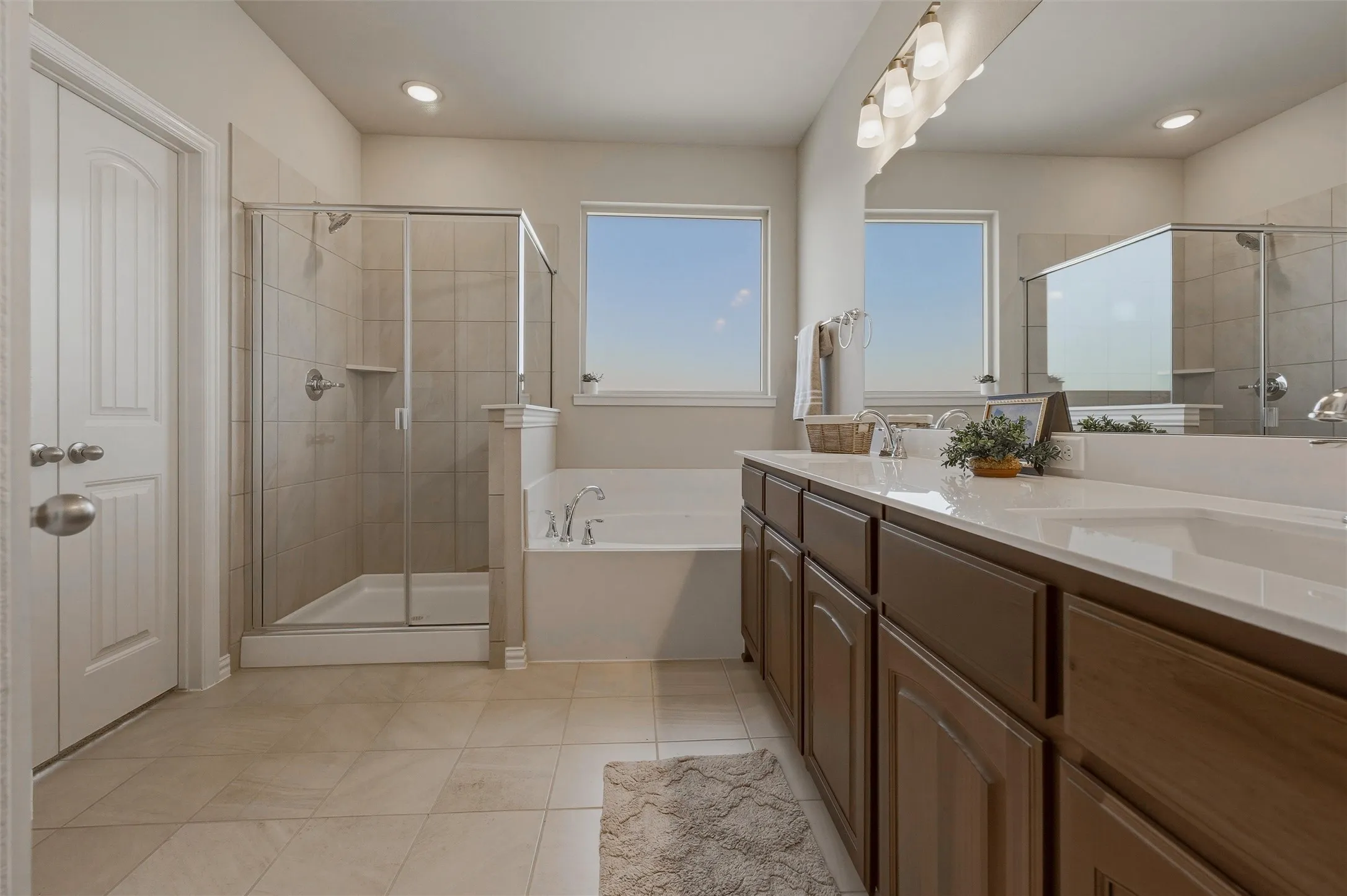 Dual sink vanity with wood-finish cabinetry and light-toned countertops