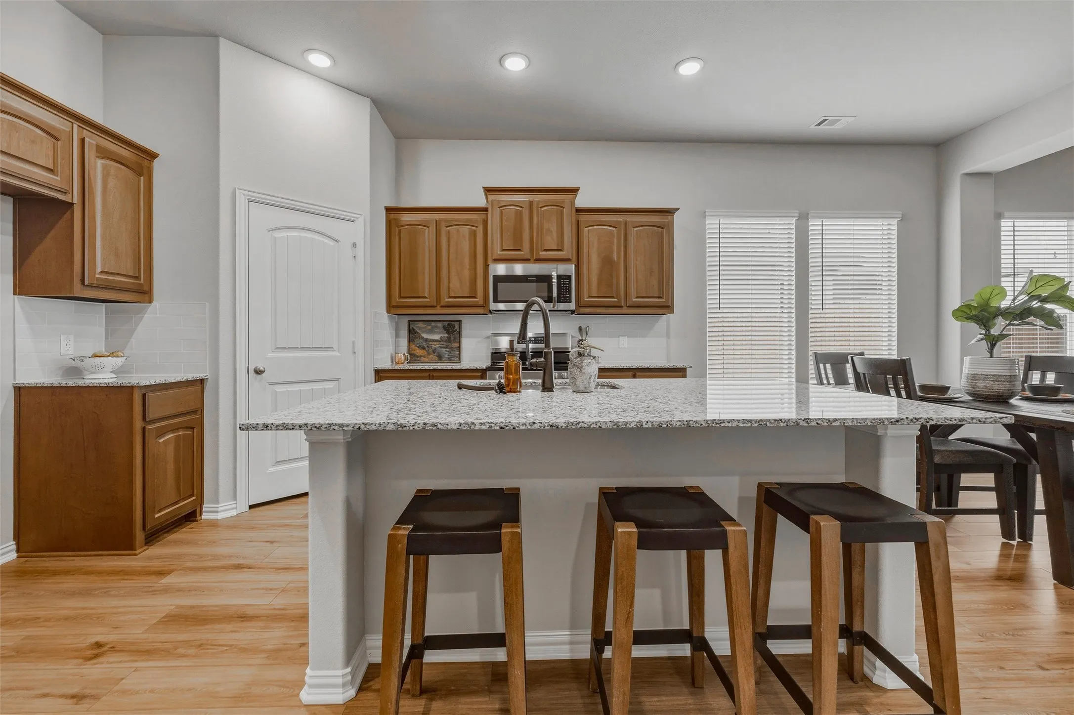 Kitchen featuring light wood-finish flooring, recessed lighting, and white subway tile backsplash