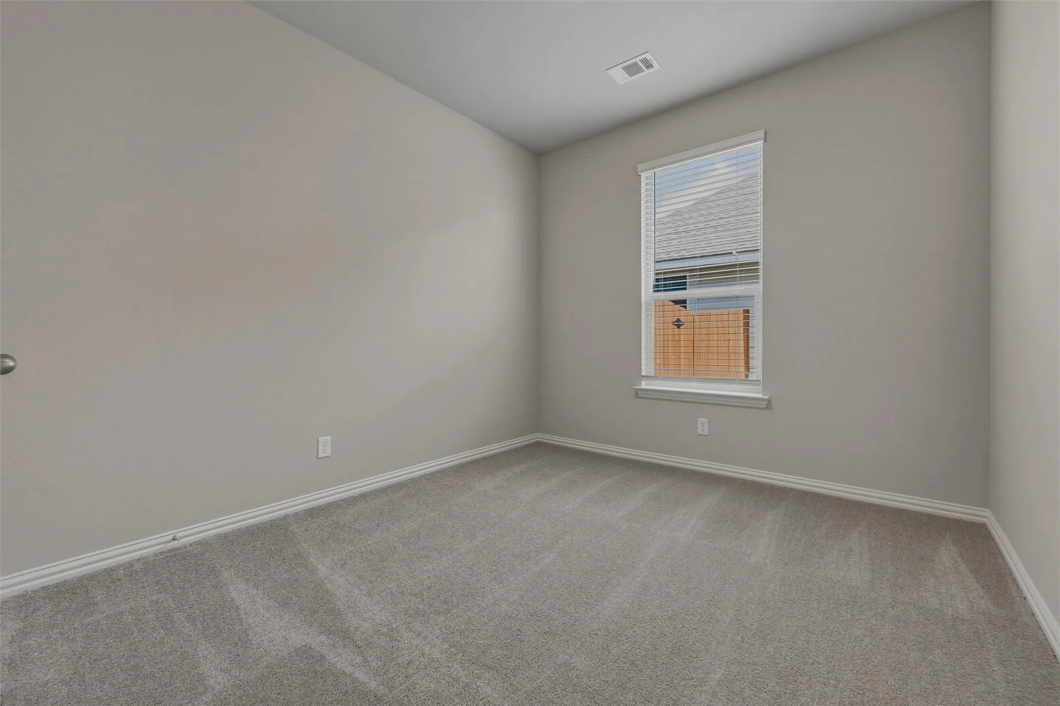 Neutral paint palette with plush carpet flooring, a window with blinds, and white trim